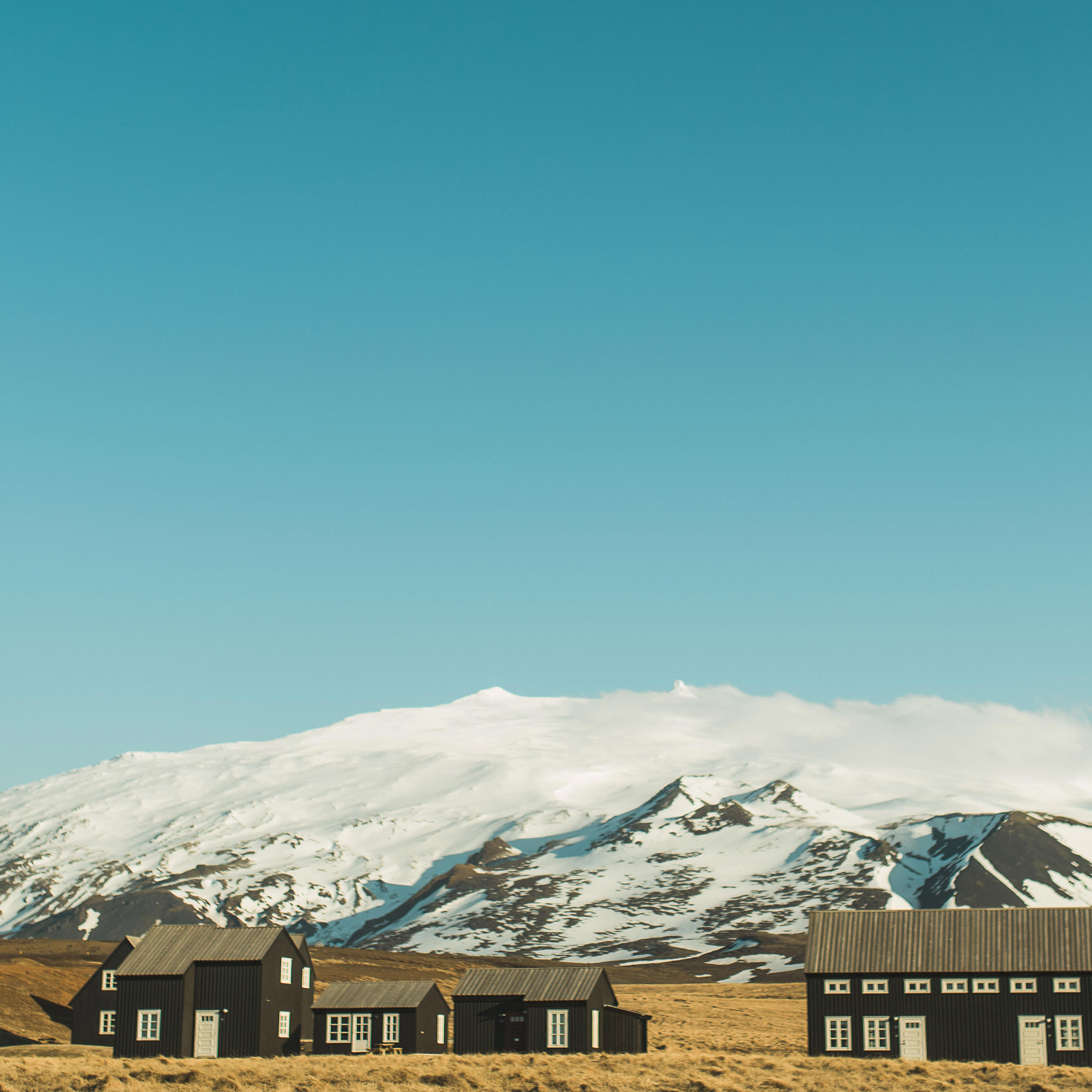 First look at Hotel Hellnar with Snæfellsjökull glacier in the background on the coastal path near Hellnar