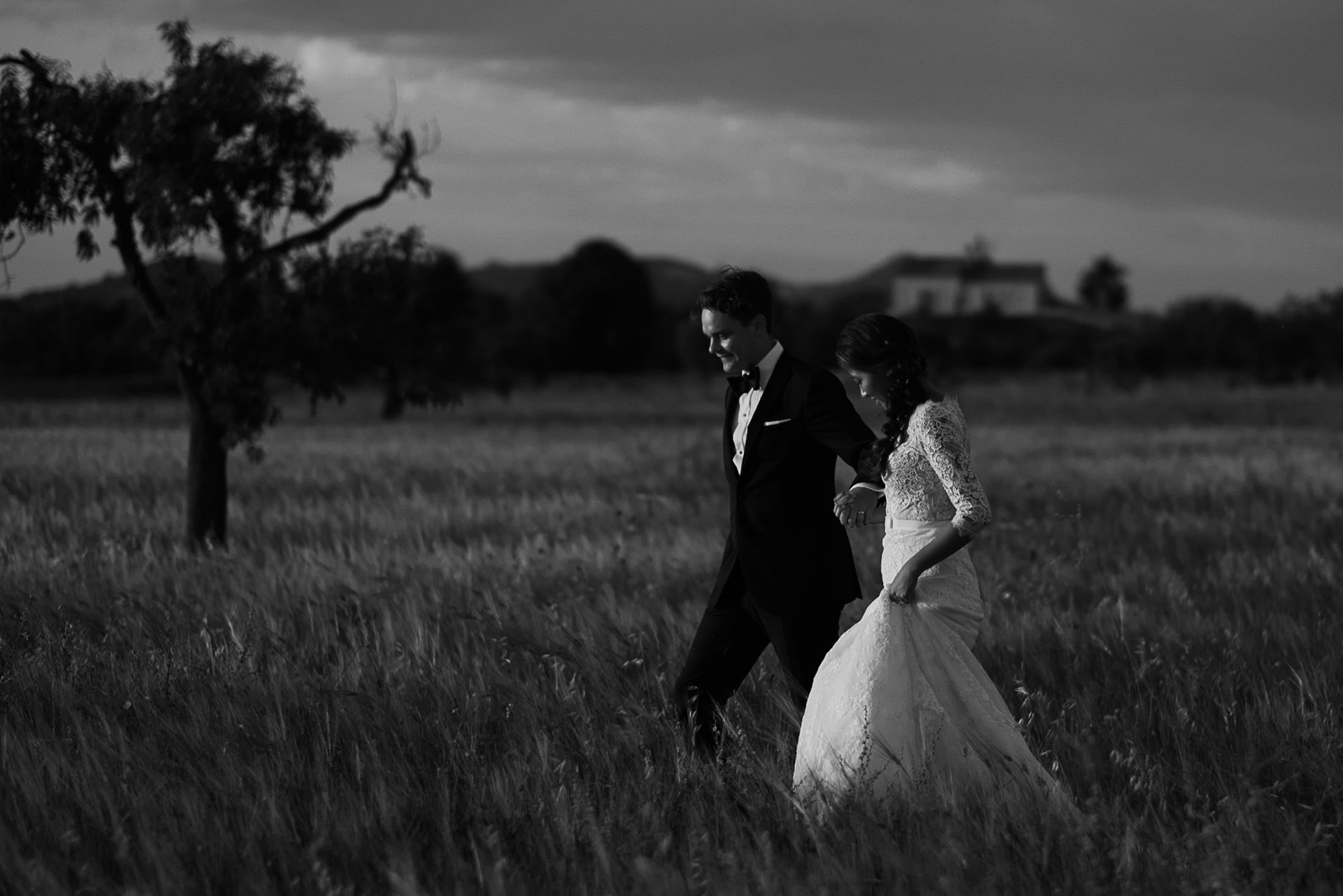Bride and groom walking a field at dusk, black and white, Mallorca