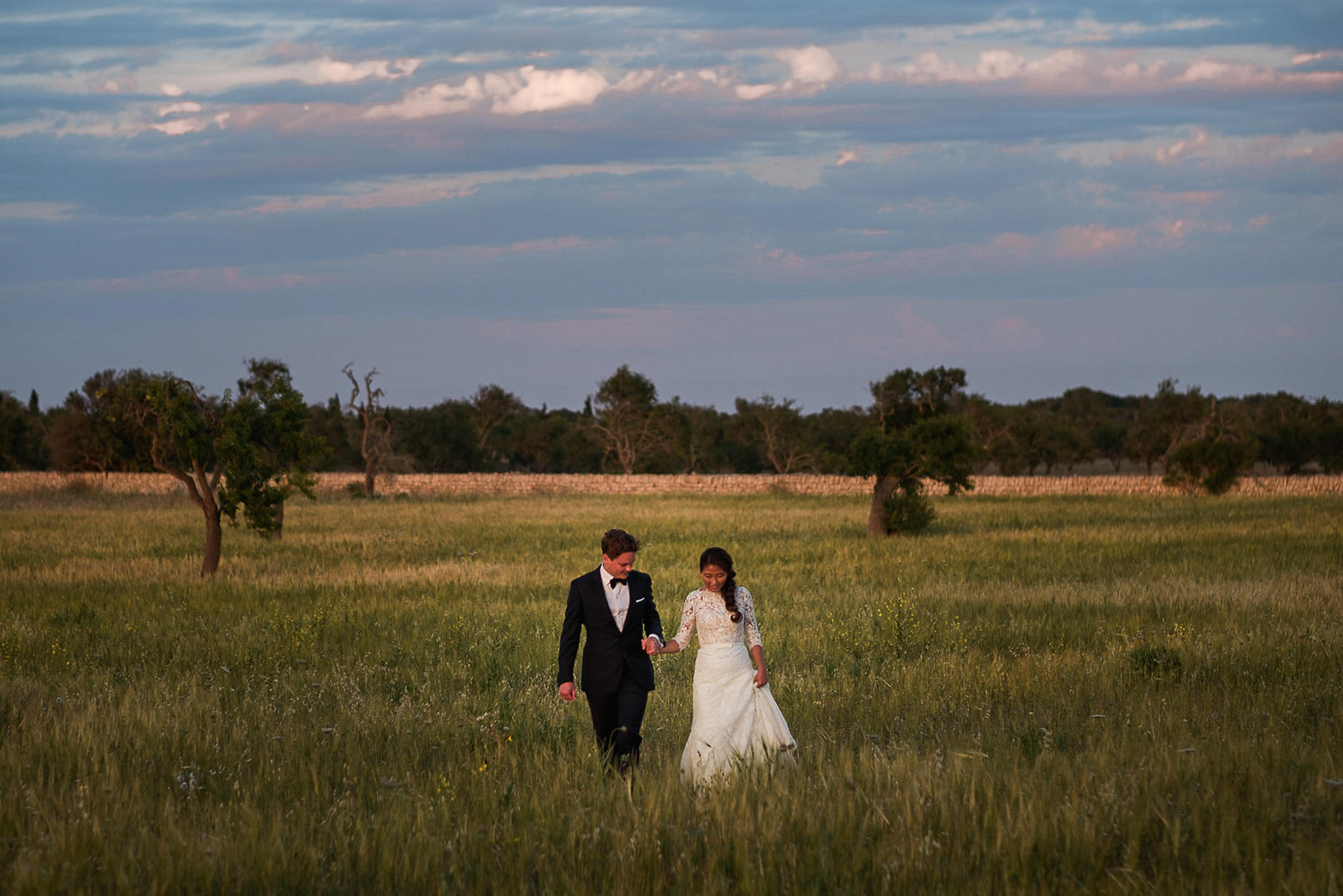 Bride and groom in a golden field at last light, Mallorca wedding