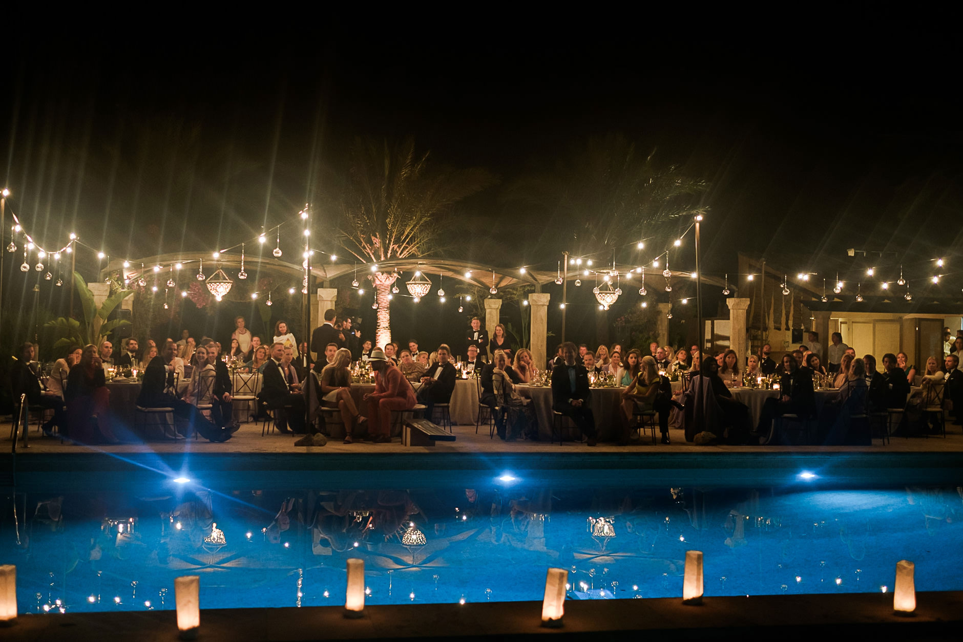String lights over the pool at a Mallorca finca wedding party