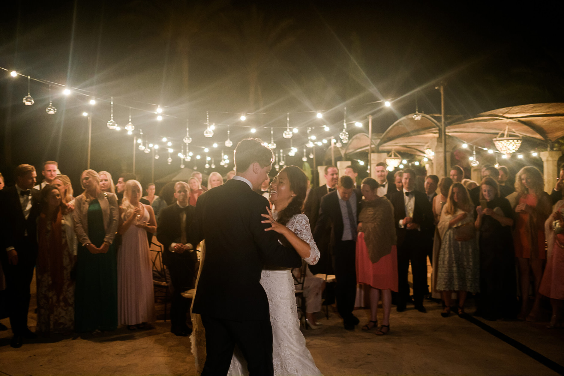 Guests dancing under string lights, Mallorca wedding