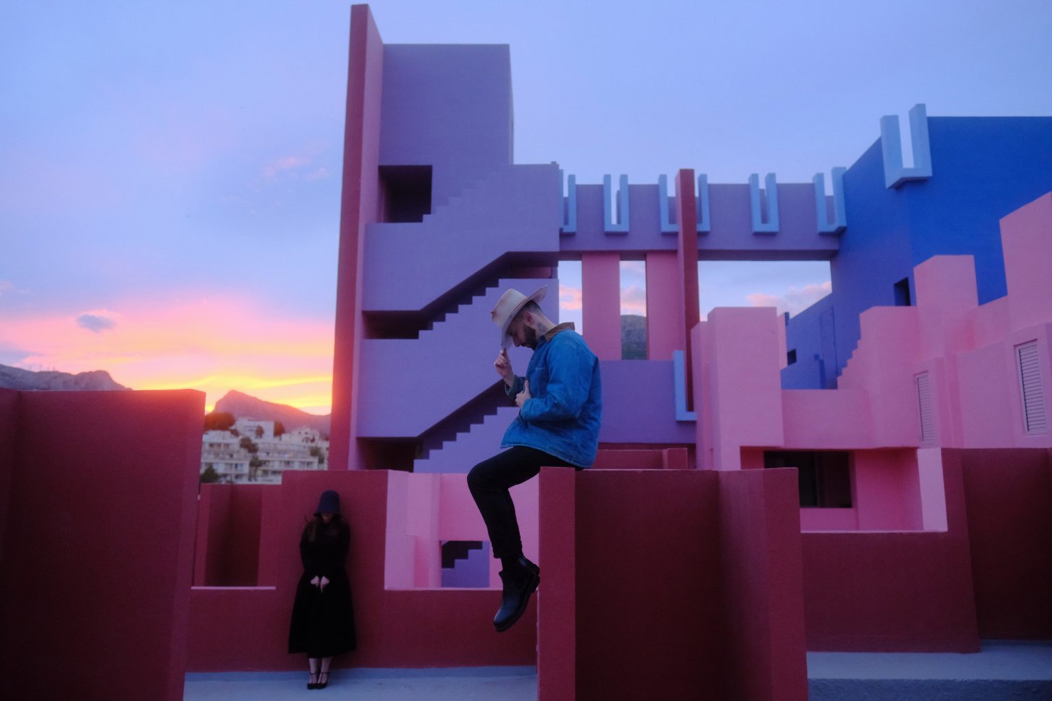 Ondrej climbing a staircase at Muralla Roja under a sunset sky in Calpe