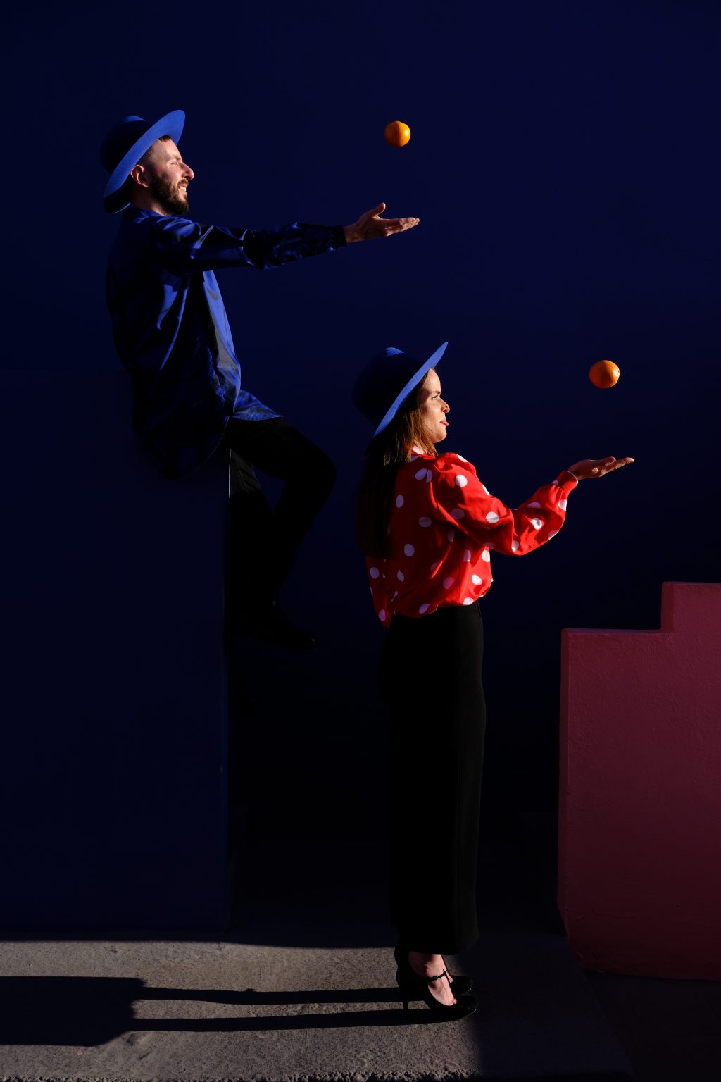 Adriana tossing an apple against the blue walls of La Muralla Roja