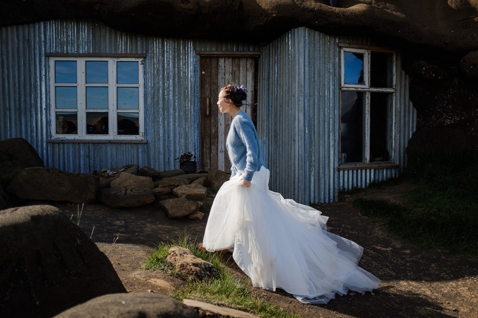 The bride at a cabin window in the Icelandic countryside