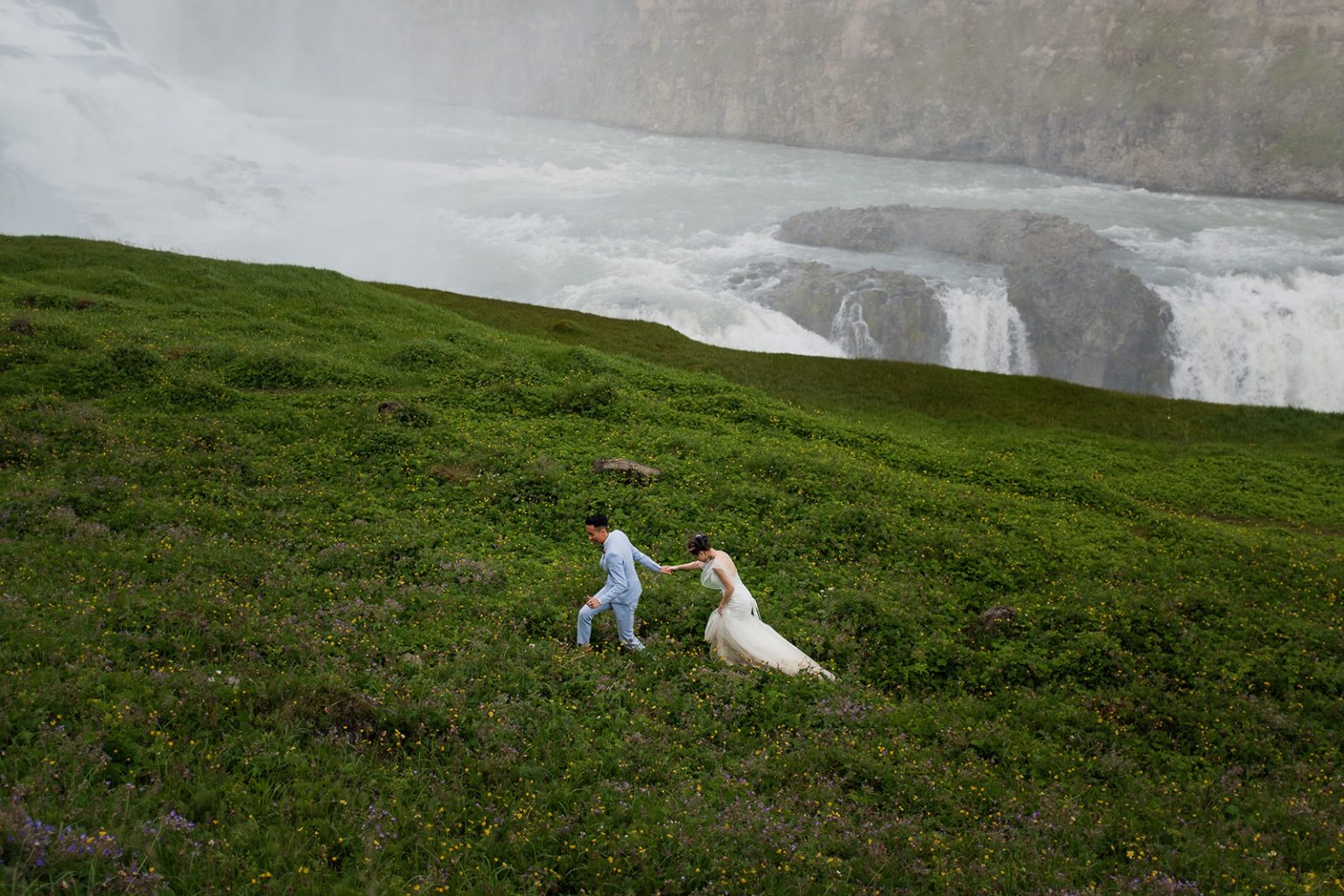 Bride and groom small against Gullfoss