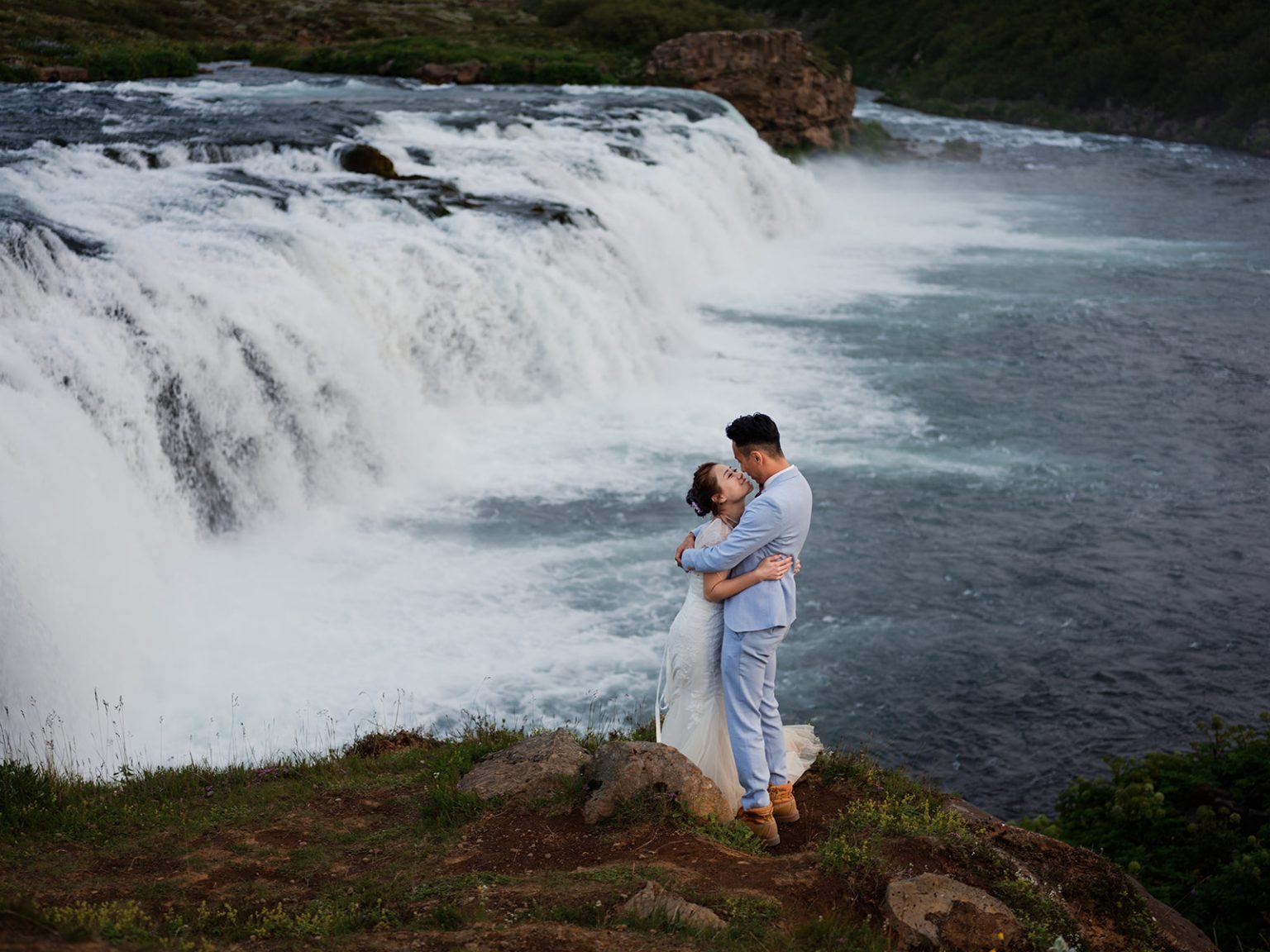Bride and groom on stepping stones over the water