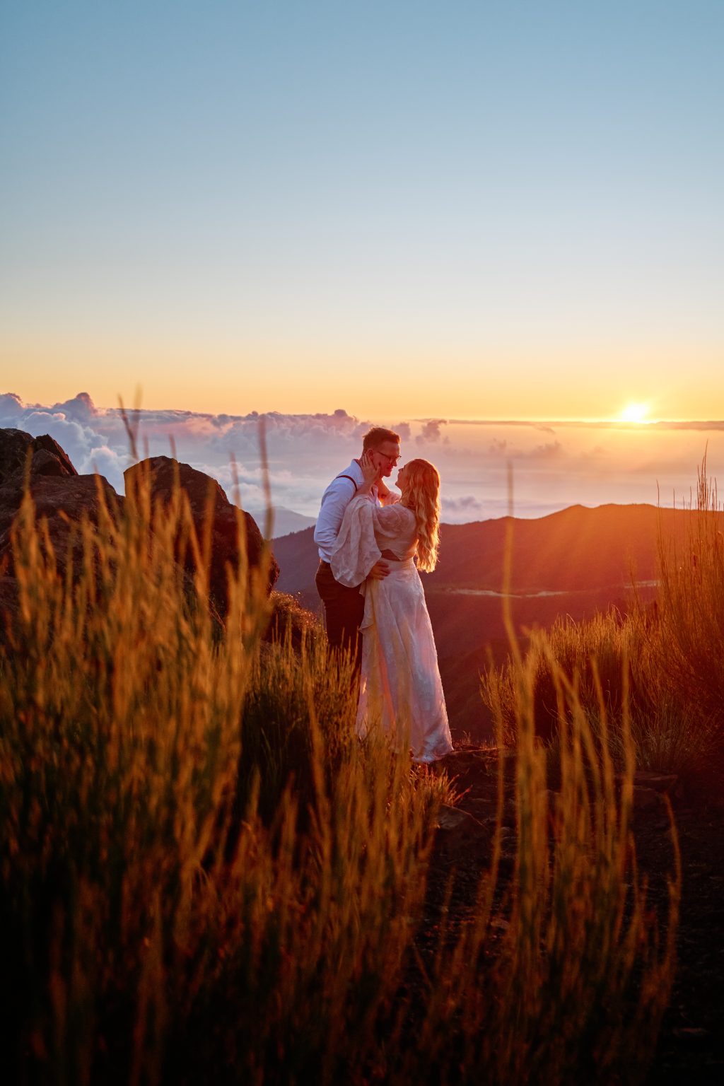Couple backlit by the rising sun on the ridge, Pico do Arieiro, Madeira