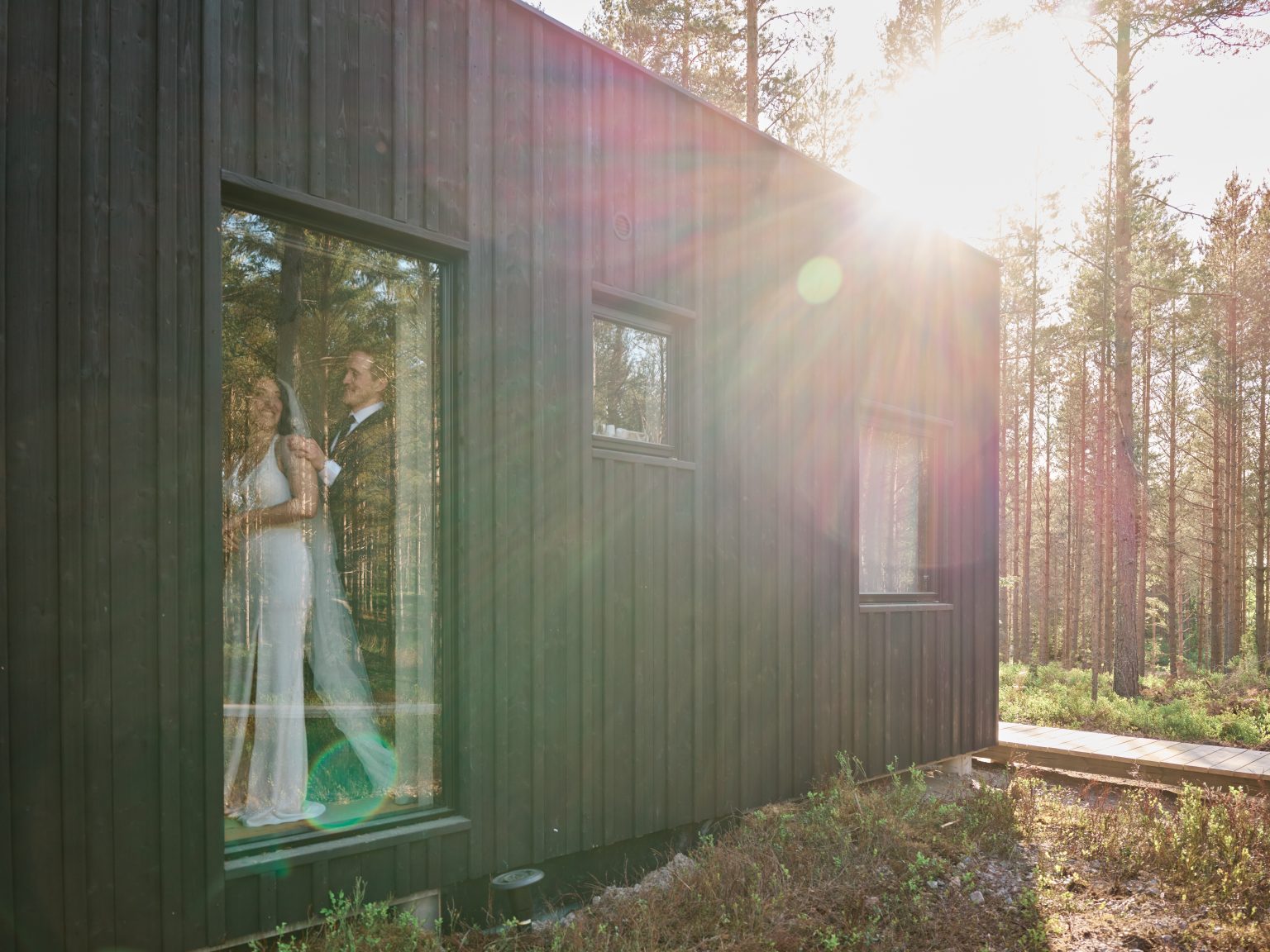 Sara and Martin reflected at the cabin window in the evening sun, Hop Farm Beach
