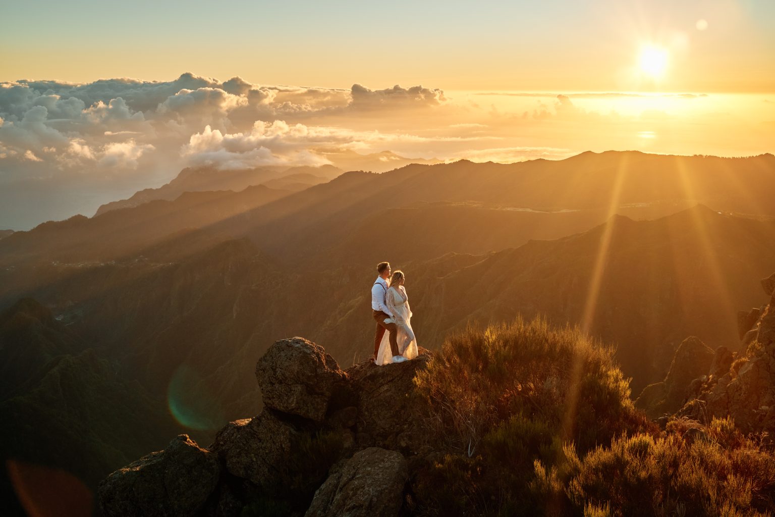 Couple on a ridge at sunrise above the clouds, Pico do Arieiro, Madeira