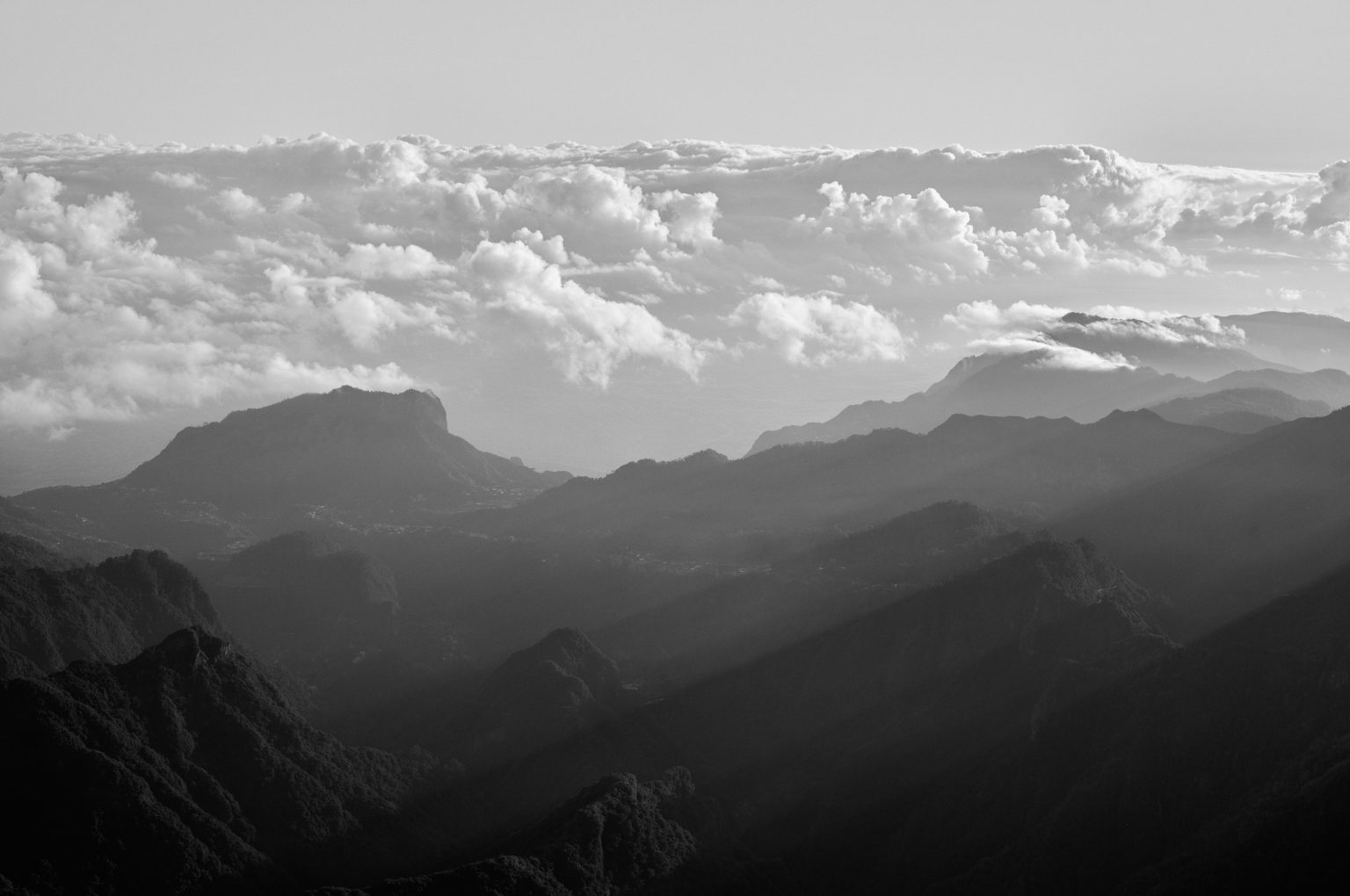 Layered mountain ridges above the clouds in black and white, Madeira
