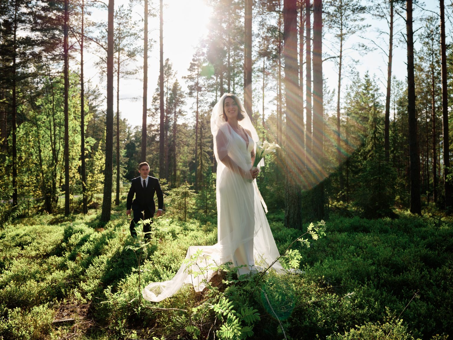 Sun flare through the forest as Martin walks to Sara, Baltic coast Sweden