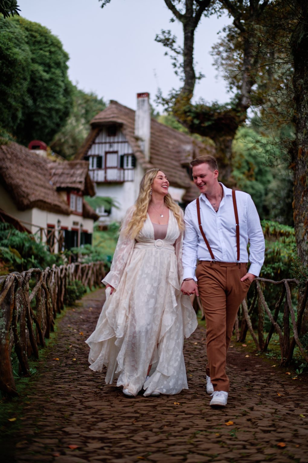 Couple by the red thatched houses of Parque Florestal das Queimadas, Madeira
