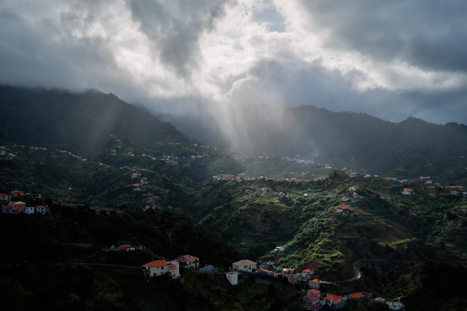 Shafts of light over the green valley at Miradouro do Boqueirao, Madeira