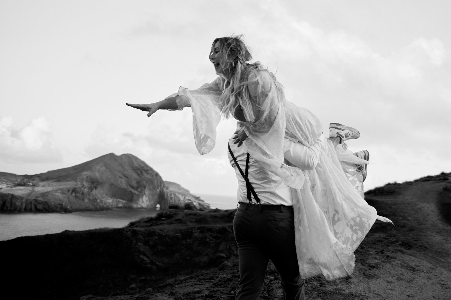 Bride dress and veil in the wind on the cliffs, black and white, Ponta de Sao Lourenco