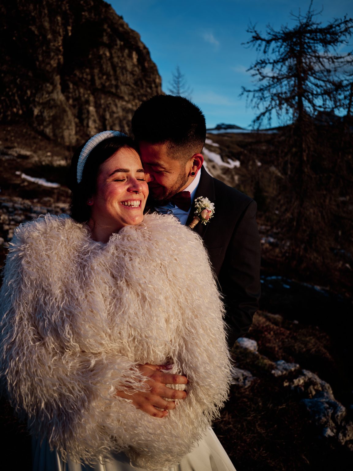 Elisa laughing with Hector at first light in the Dolomites, wrapped against the cold