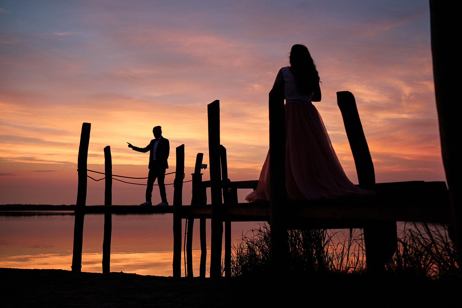 Irene and Jan silhouetted on a wooden jetty at sunrise near Copenhagen