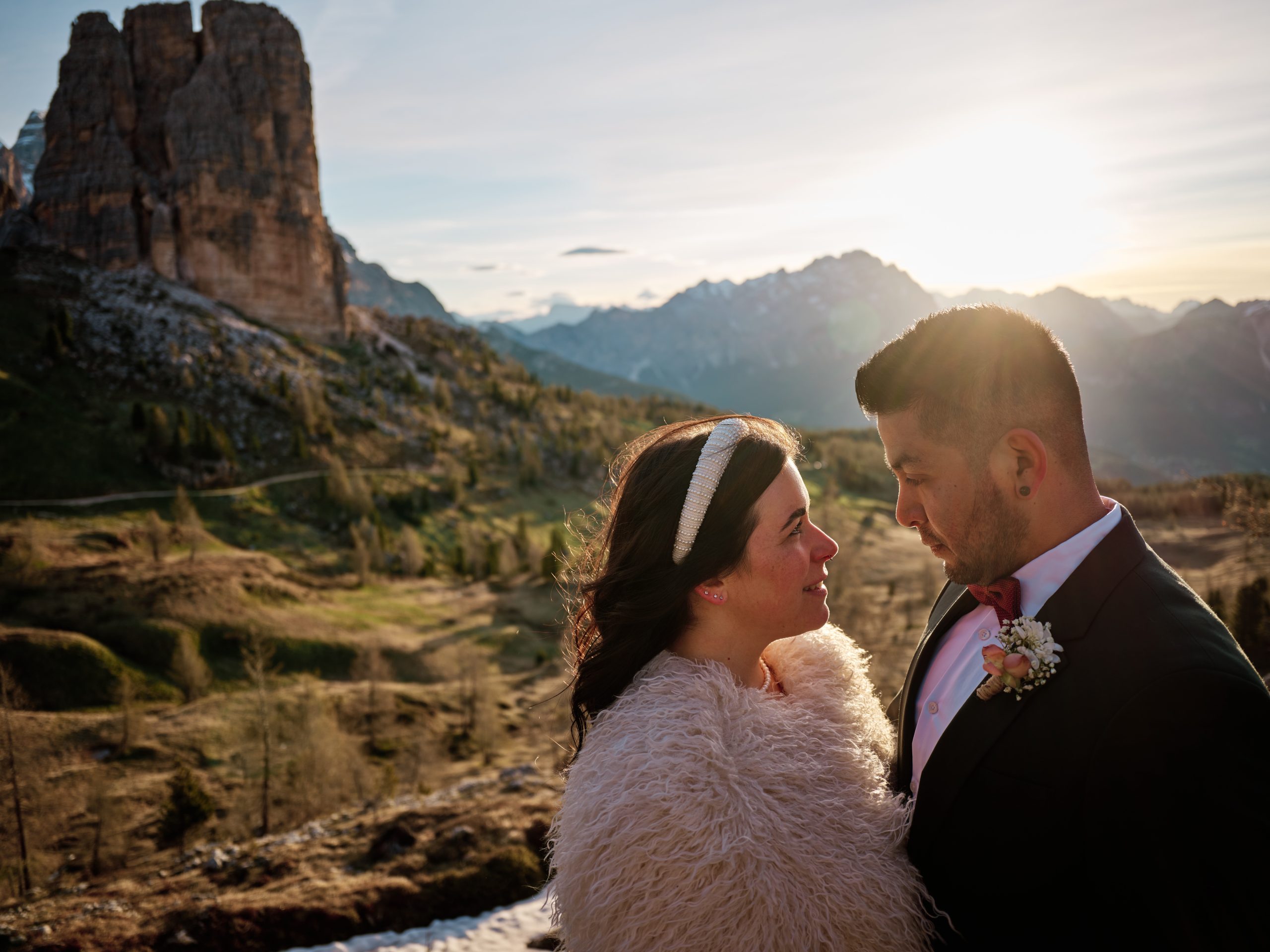 Elisa and Hector forehead to forehead in the morning light, Dolomites peaks behind