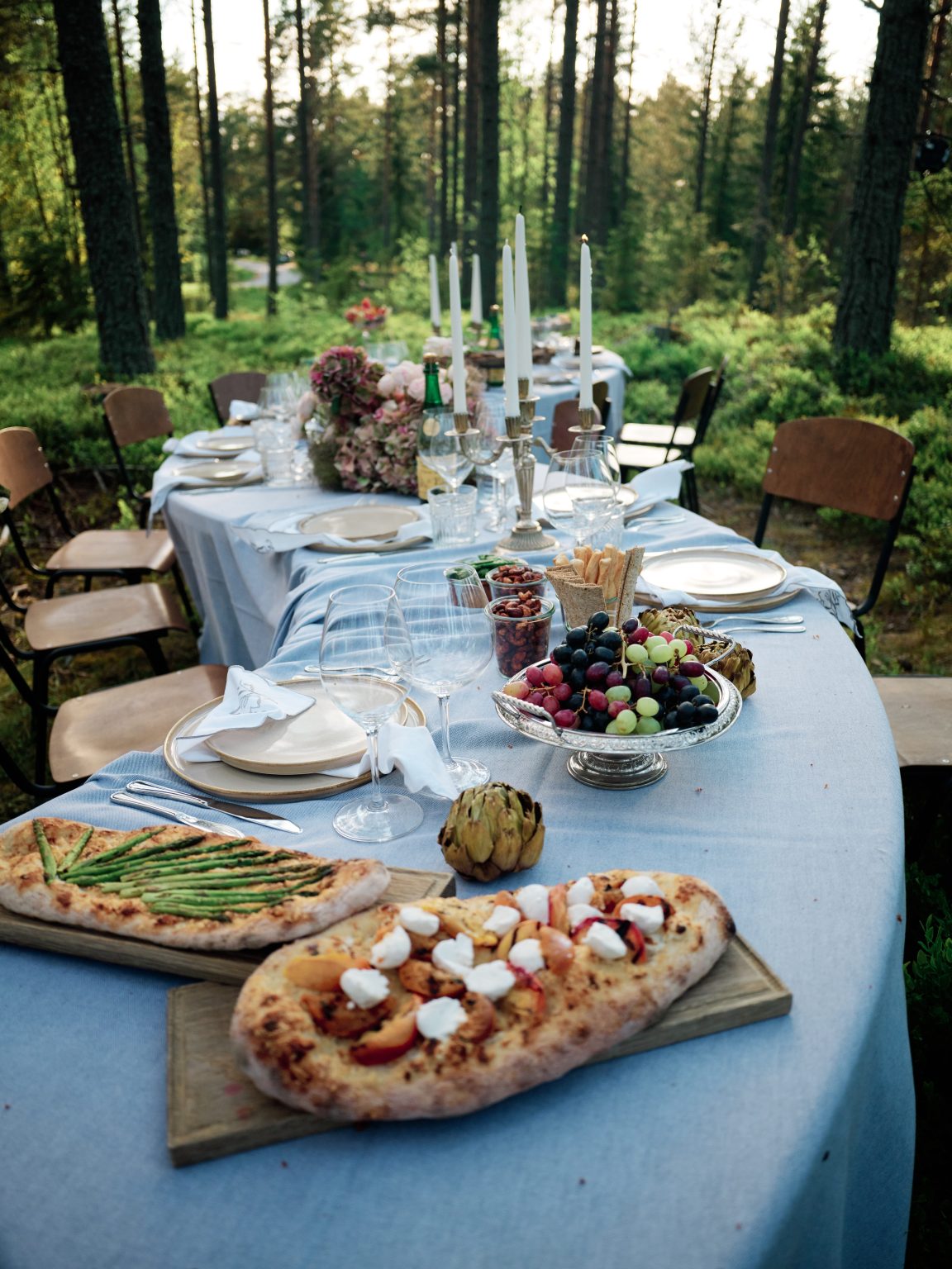 Linen, fruit and place settings on the forest wedding table