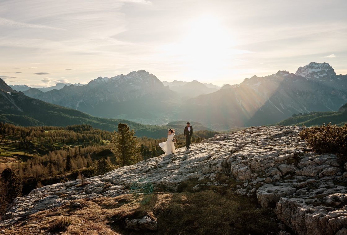 Elisa and Hector small in the Dolomites landscape at sunrise, Cinque Torri engagement session by Nordica Photography