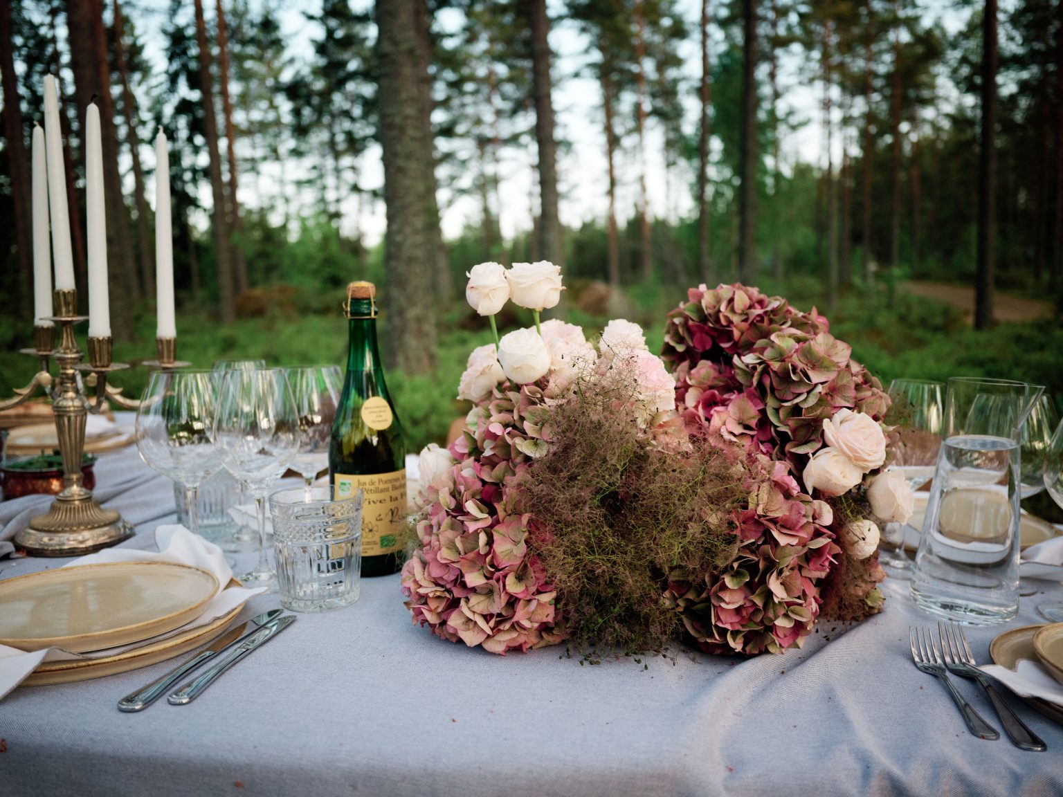 Hydrangeas, champagne and candlelight on the forest table