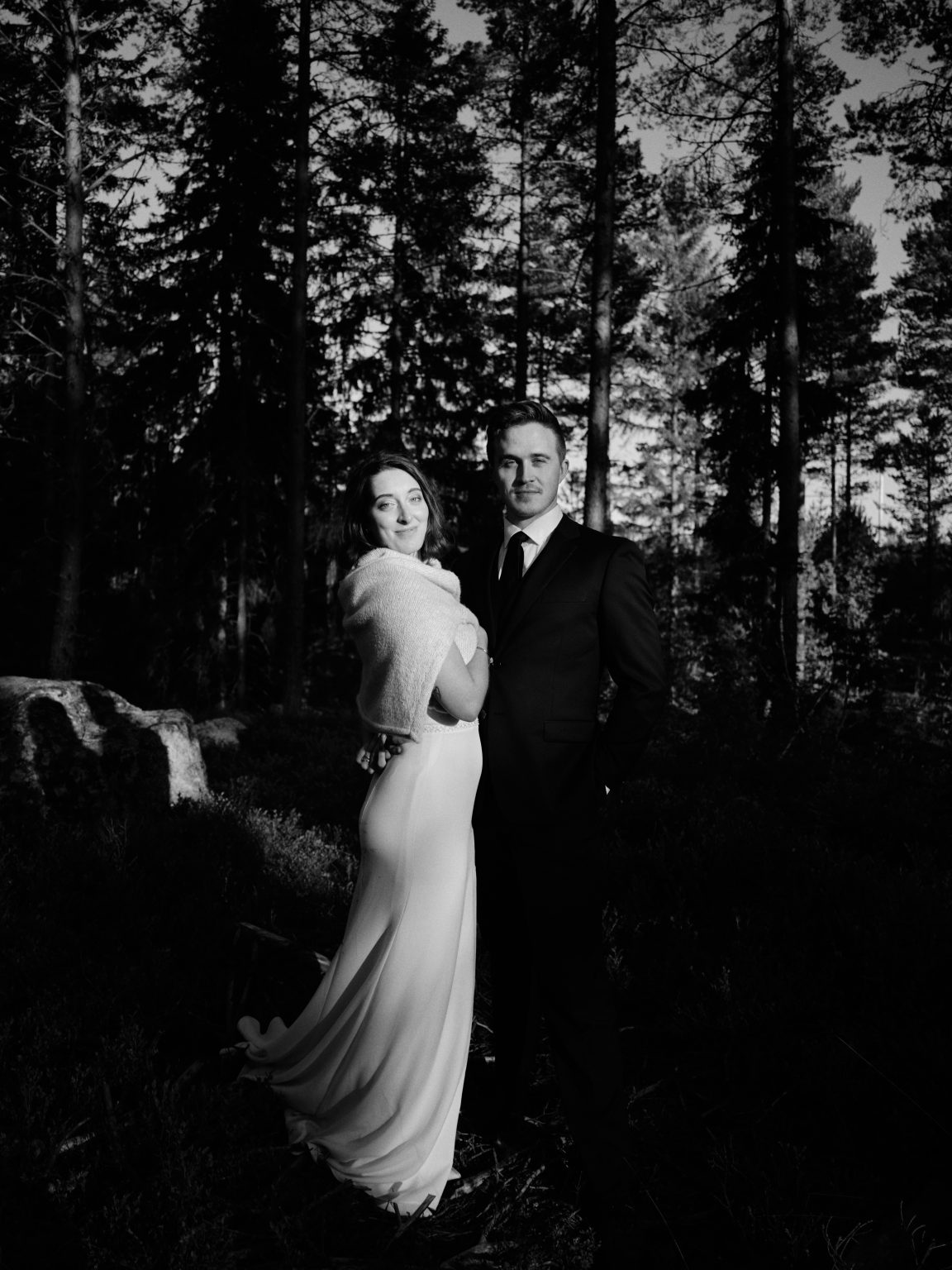 Black and white portrait of Sara and Martin by the stone wall
