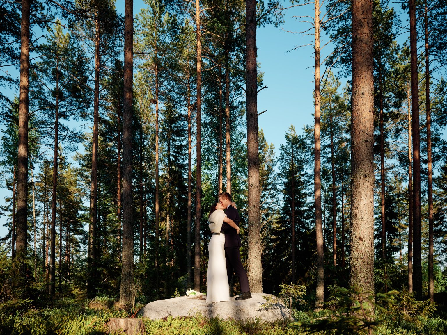 Sara among the tall pines under a blue sky, Hälsingland Sweden