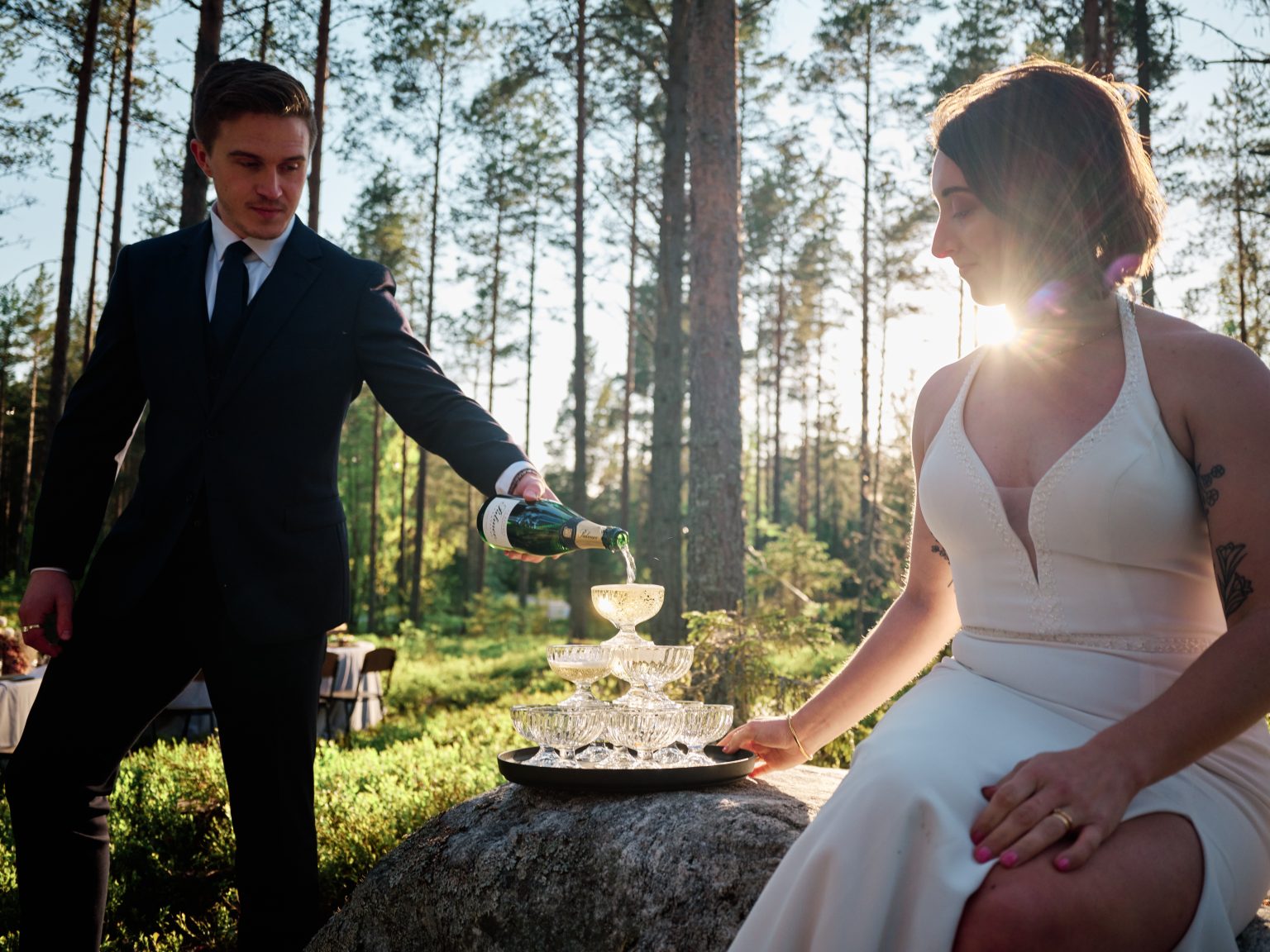 Martin pouring the champagne tower while Sara watches