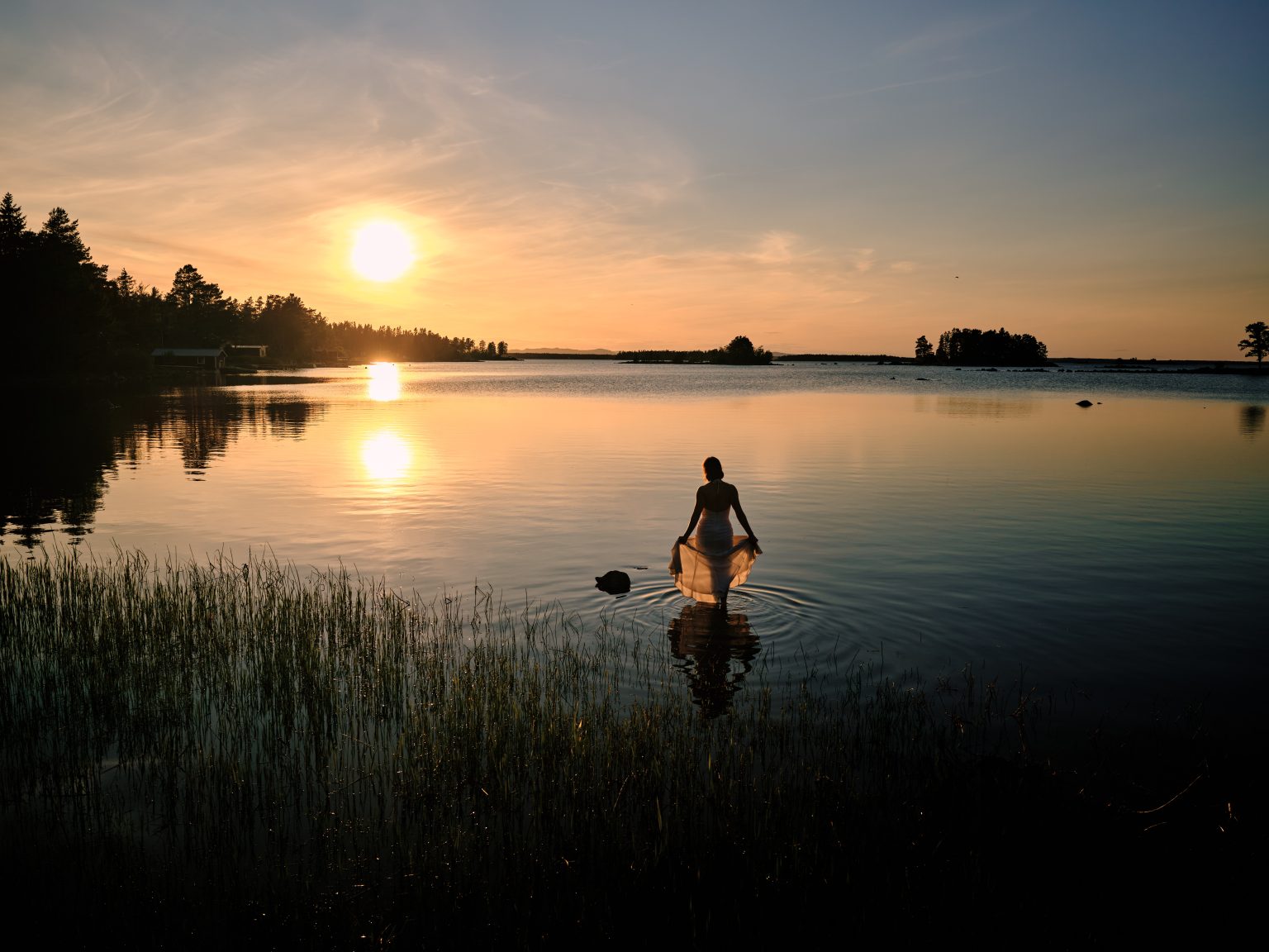 Sara wading into the Baltic at sunset near the cabin