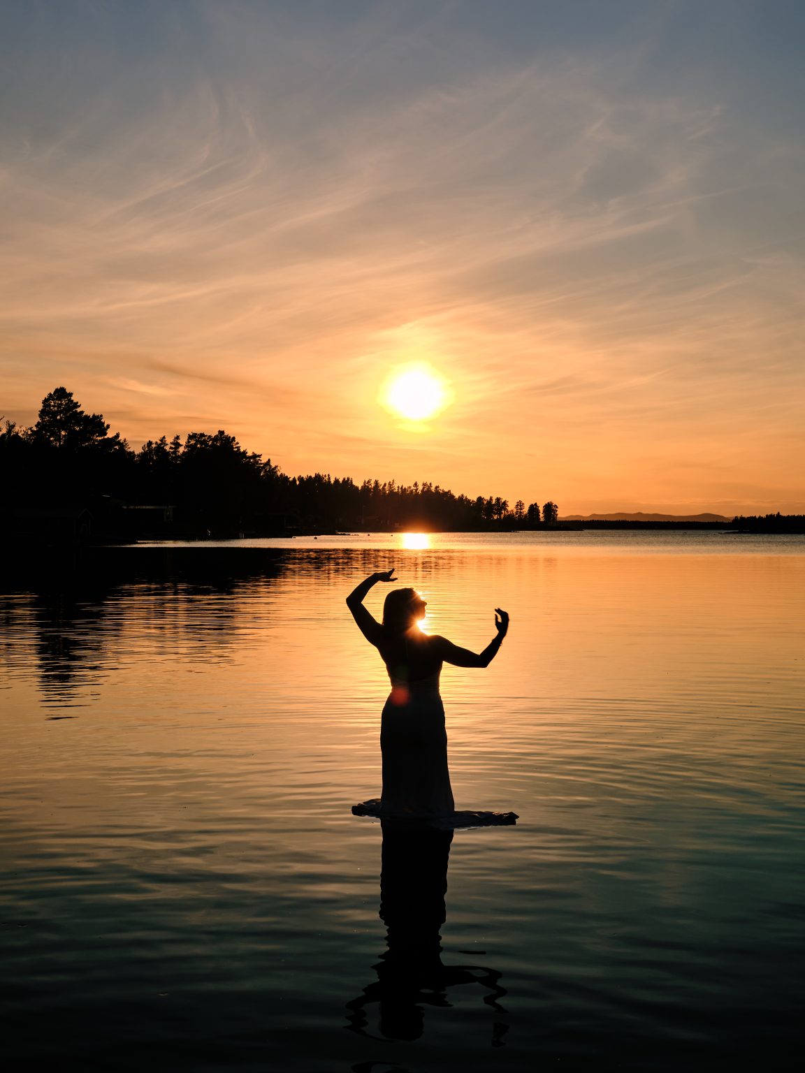 Sara dancing in the sea with the midnight sun above