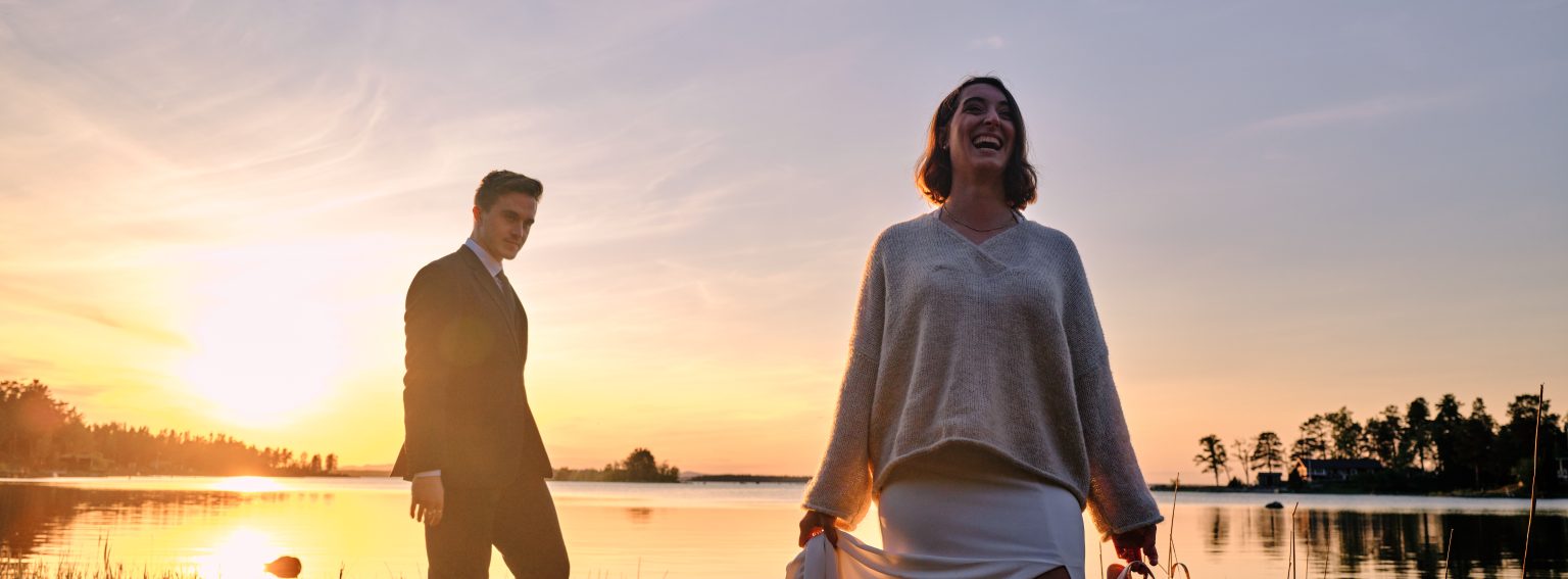 Sara and Martin laughing on the shoreline at sunset