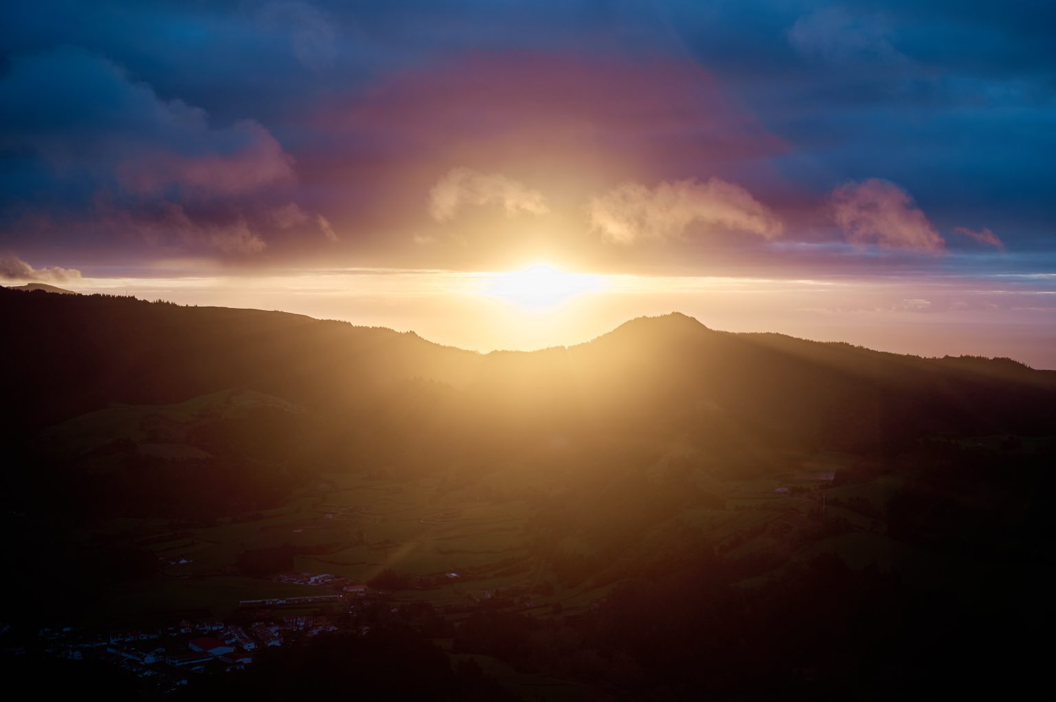 Sunrise breaking over the Furnas valley from the Miradouro do Salto do Cavalo, São Miguel
