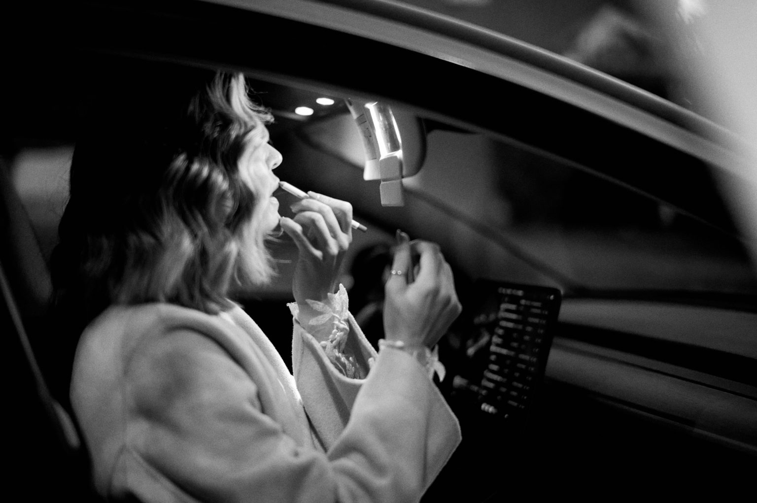 Ana finishing her make-up in the car mirror before a sunrise elopement session in Lisbon