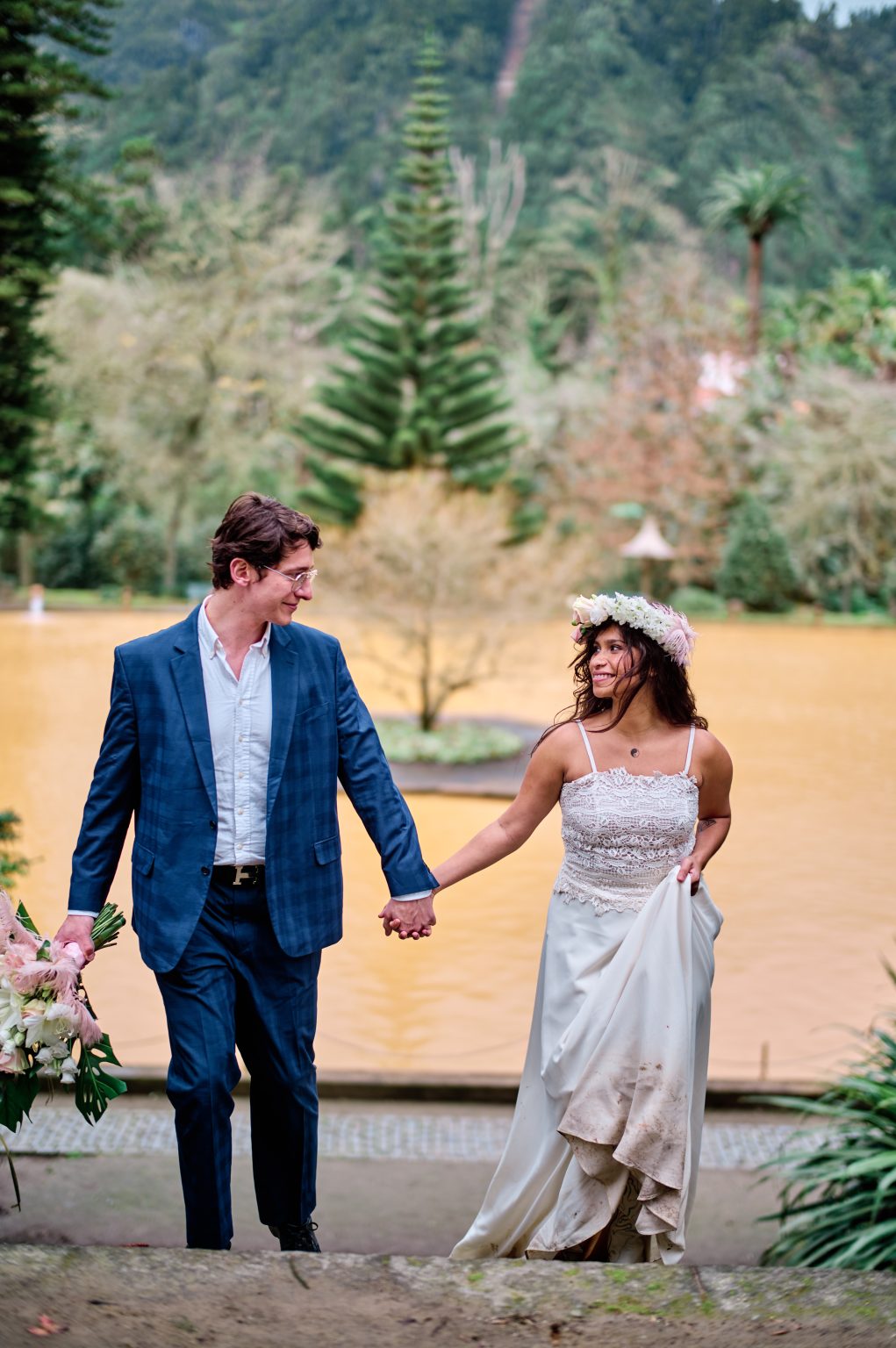 Couple beside the rust-orange thermal pool at Parque Terra Nostra, São Miguel