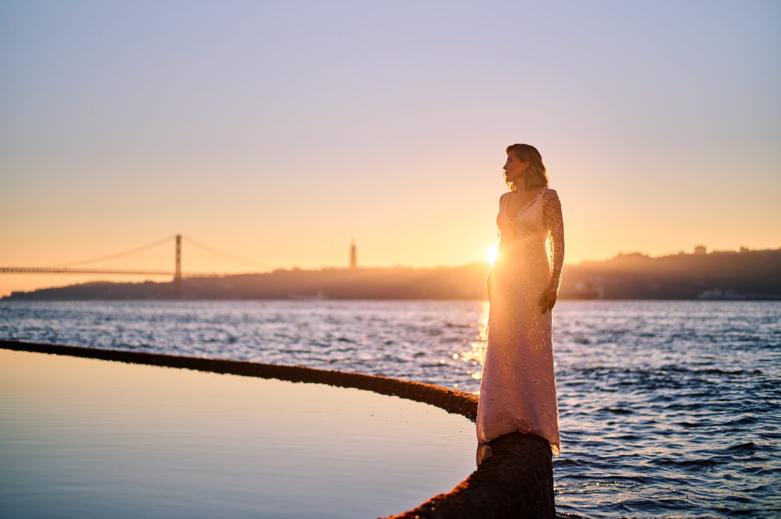 Ana silhouetted at the water’s edge at sunrise in Belém