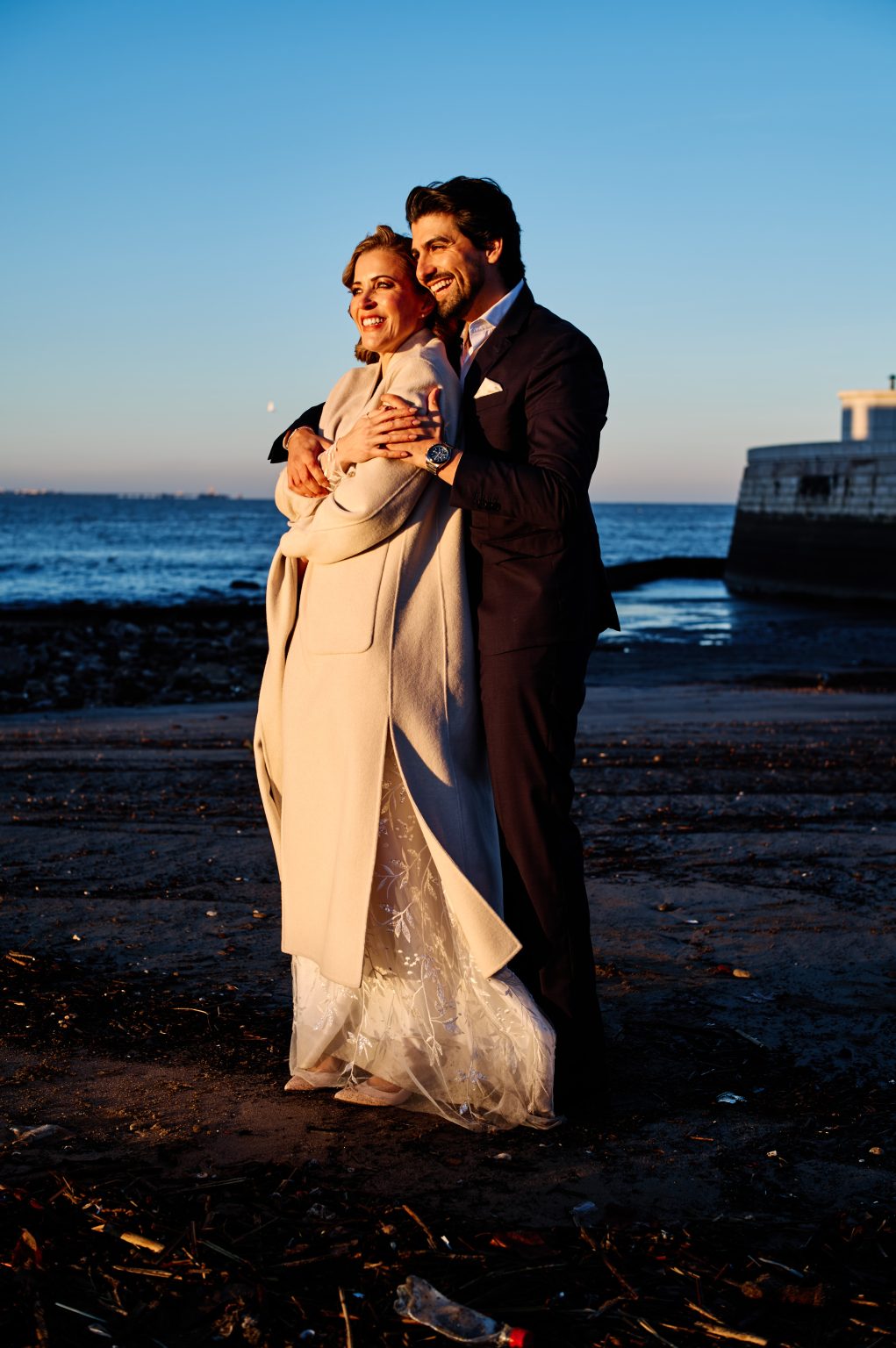 Ana and David on the small beach below the seawall in Belém