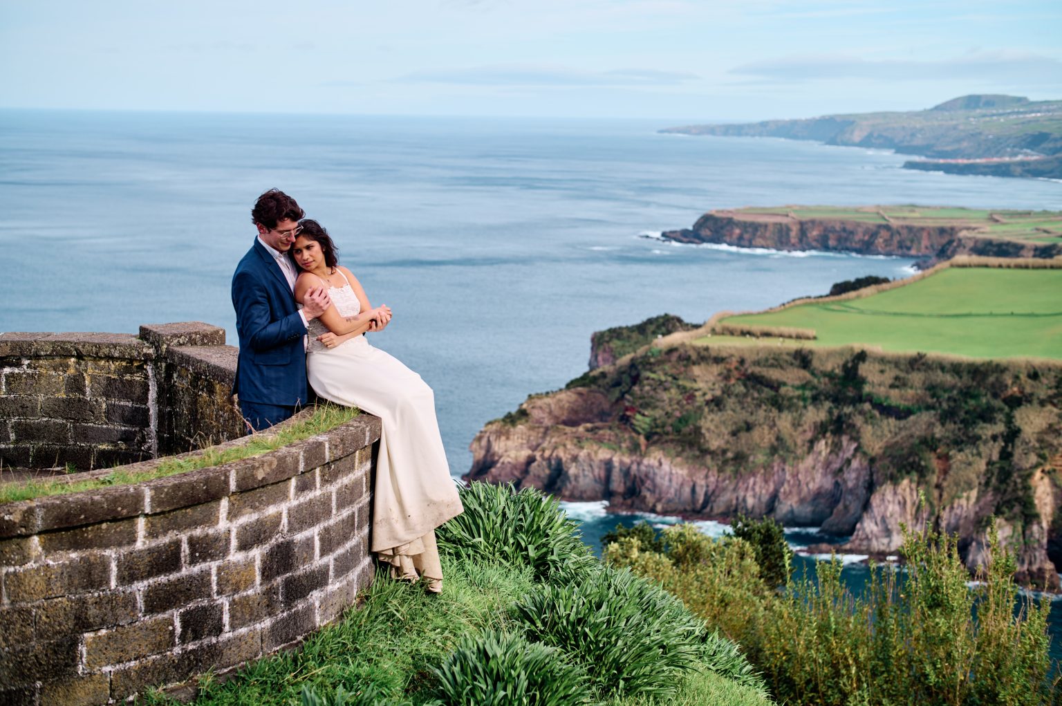 Couple on a viewpoint wall over the coast, São Miguel, Azores