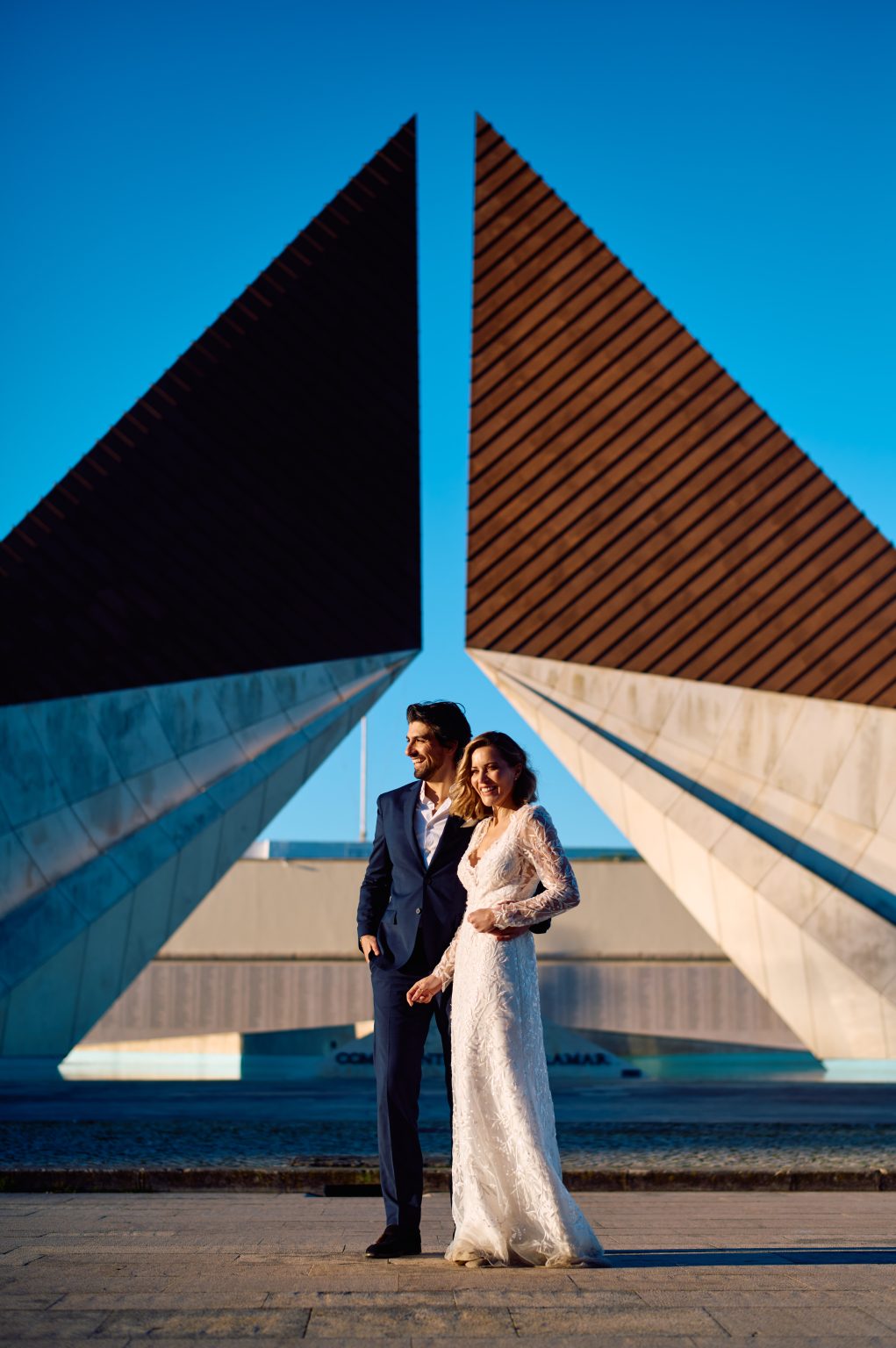 Ana and David beneath sharp modern architecture in Belém