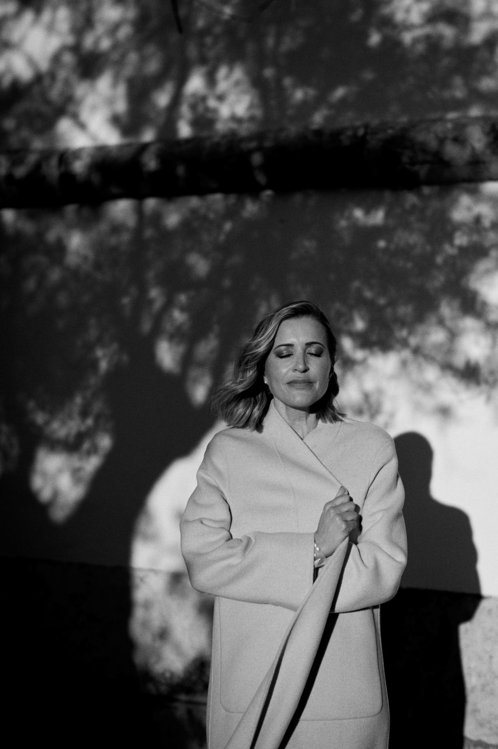 Black and white portrait of Ana in dappled tree shadow in Lisbon