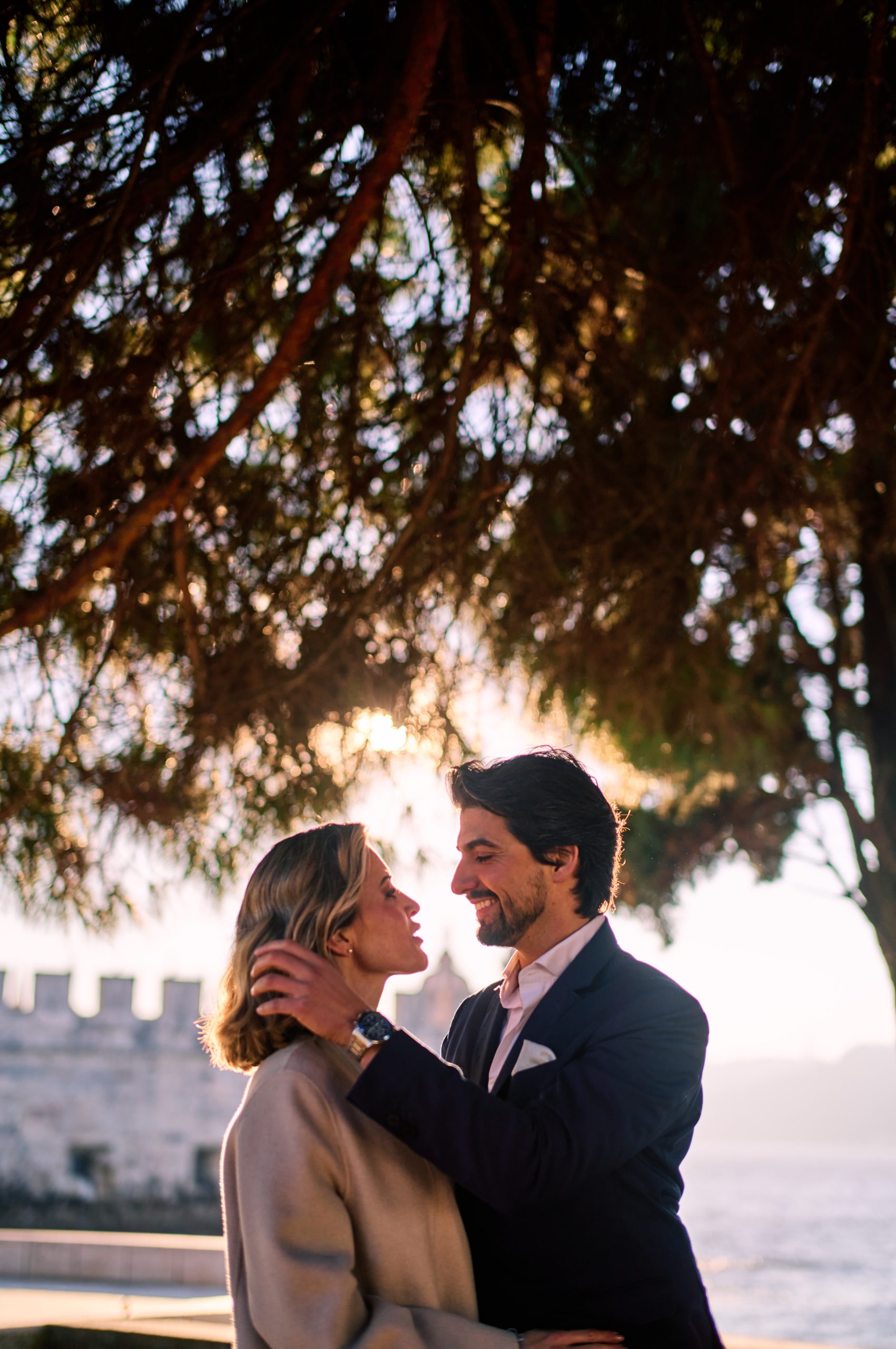 Ana and David under a pine tree in golden morning light in Lisbon