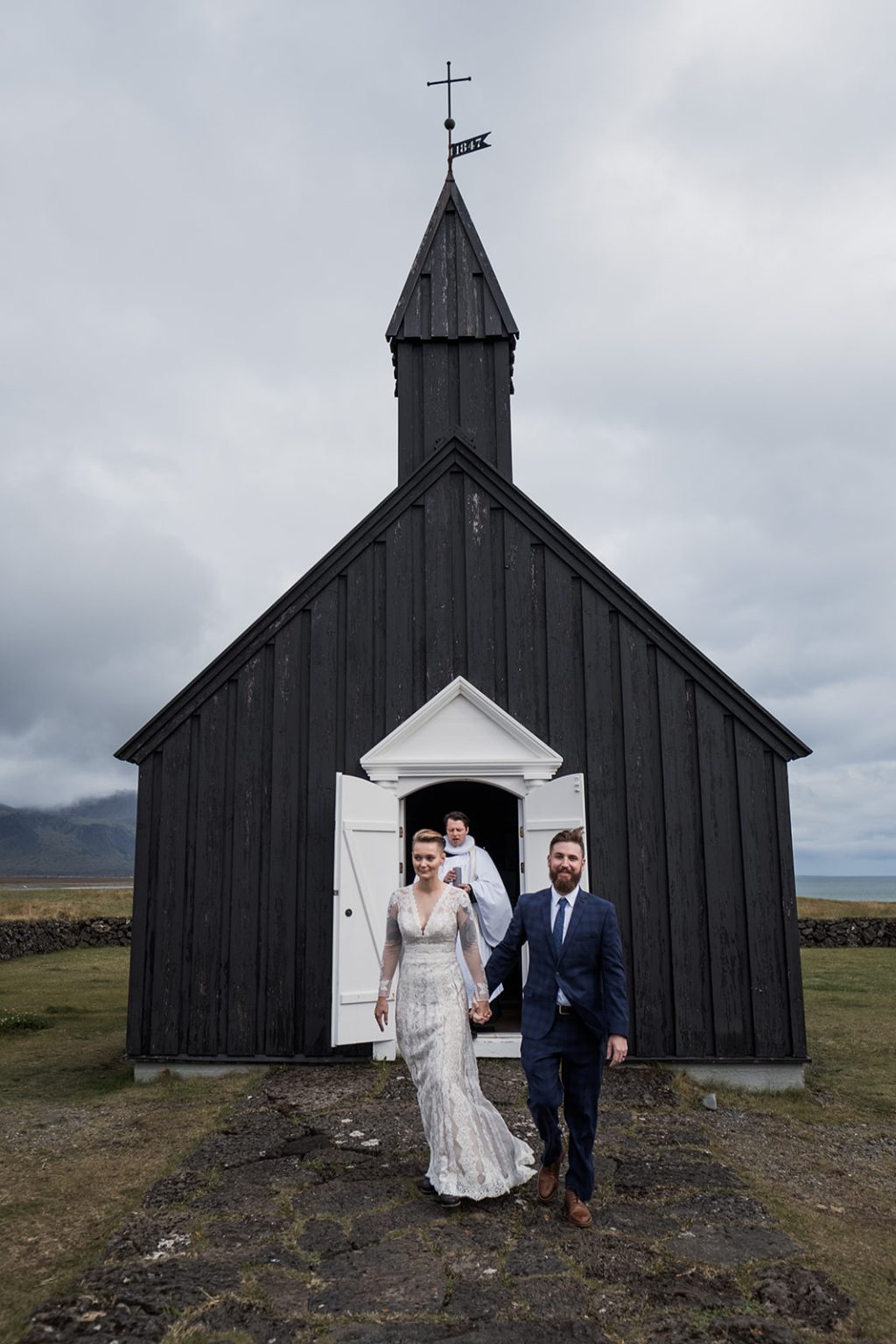 Amelia and Adam leaving the black church, a Hótel Búðir wedding
