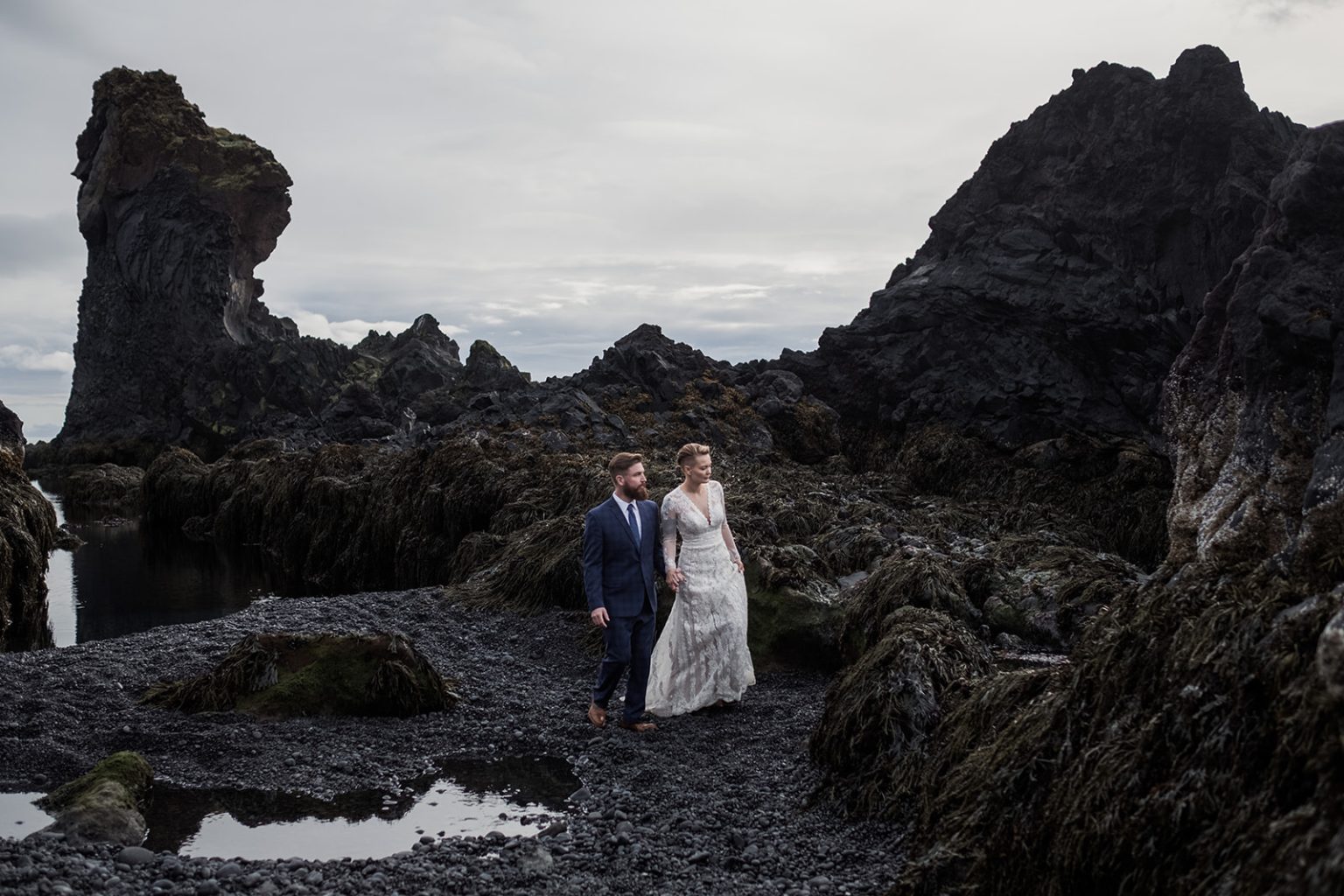 Amelia and Adam reflected in a lava pool, Búðir, Iceland