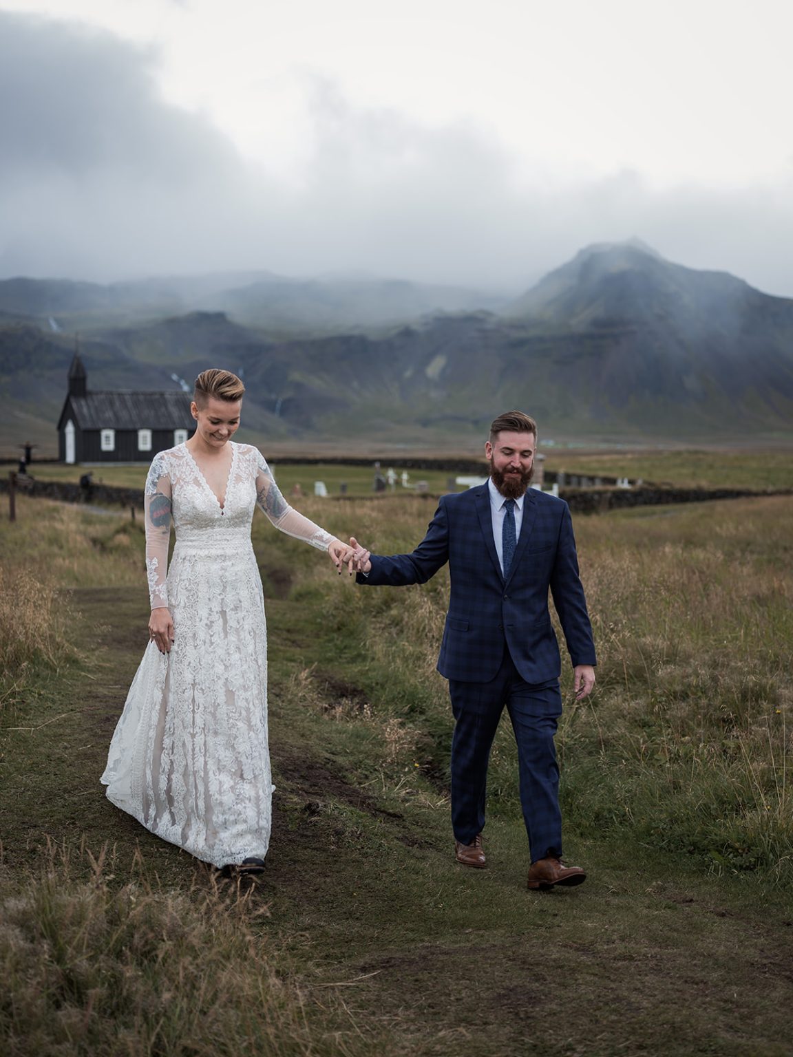Holding hands in a green field, Snæfellsnes, a Hótel Búðir wedding