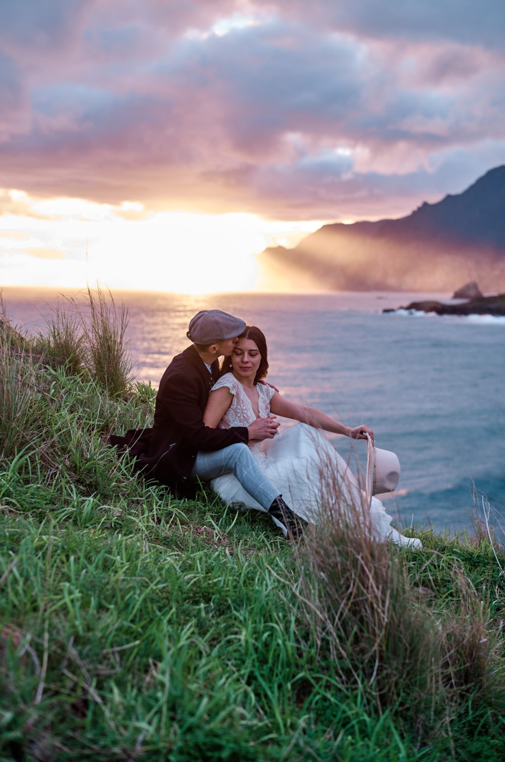 Couple at sunrise on the clifftop grass, Miradouro do Guindaste, Madeira