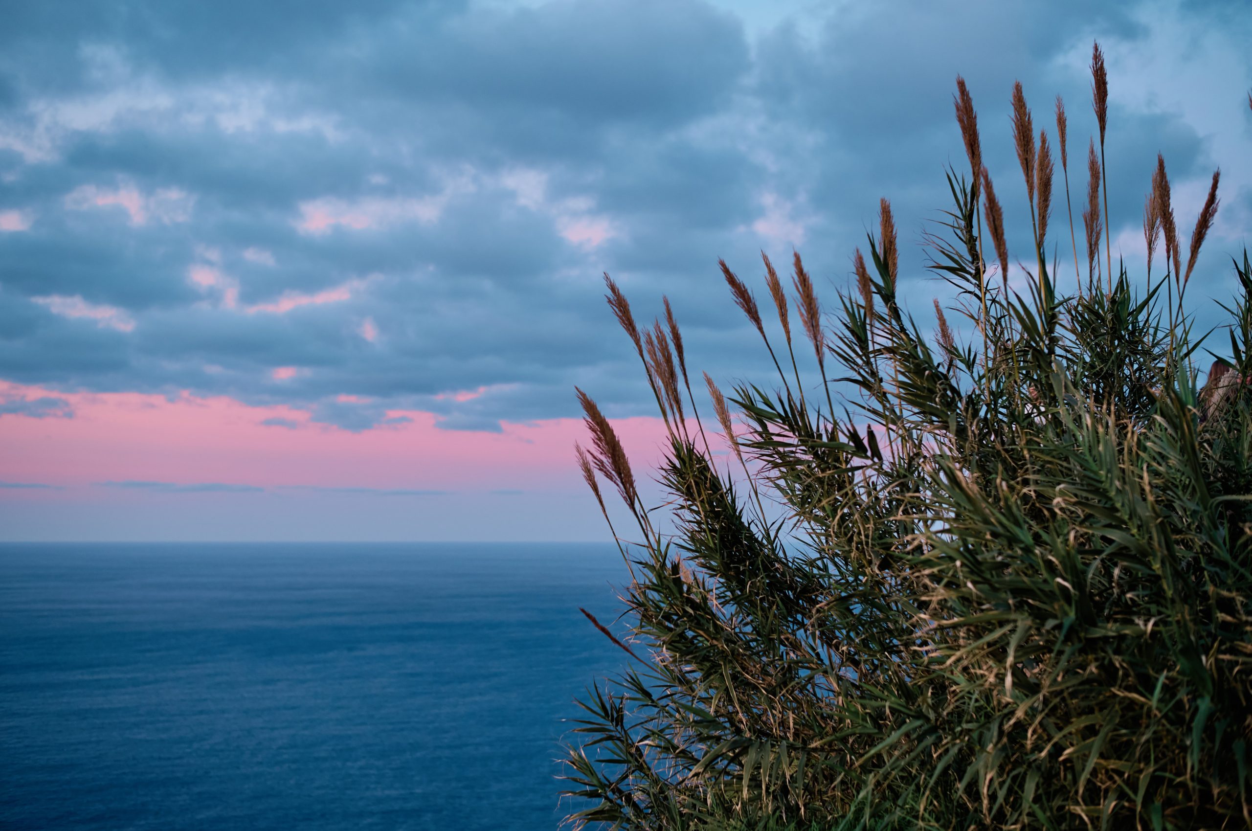 A couple on the red cliffs of Ponta de Sao Lourenco at sunrise