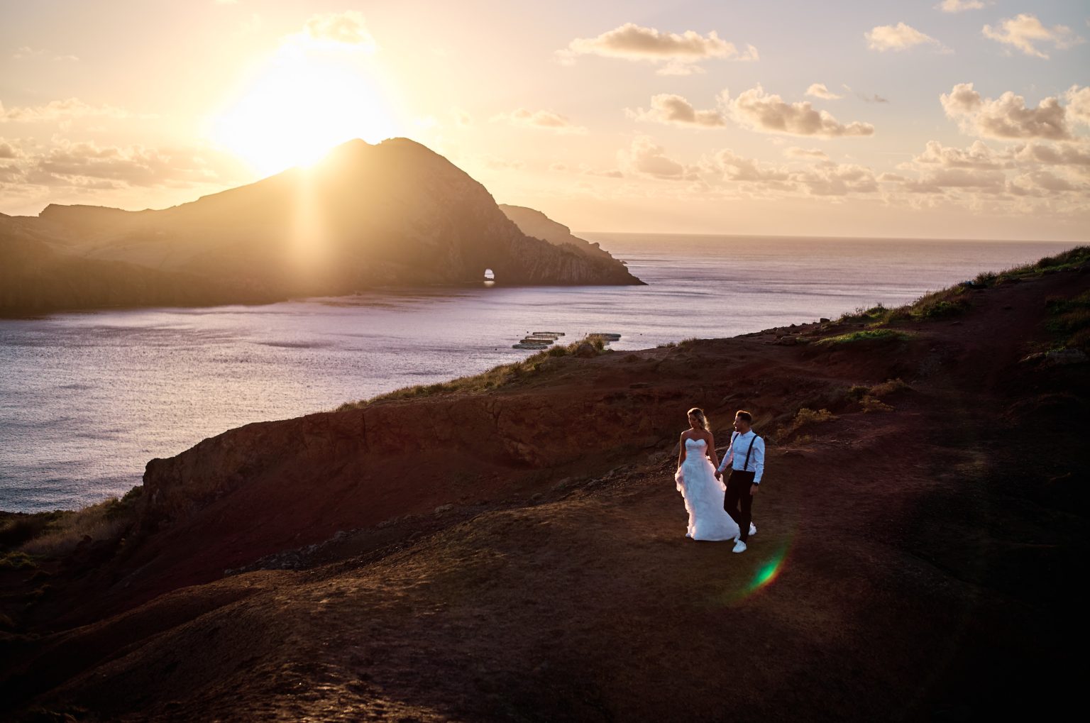 Couple on the headland as the sun rises over Ponta de Sao Lourenco, Madeira