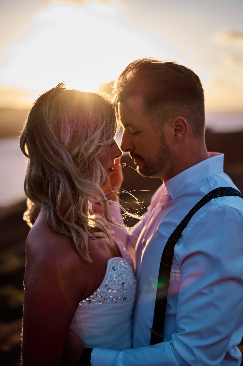 Couple foreheads together in warm sunrise light, Ponta de Sao Lourenco, Madeira