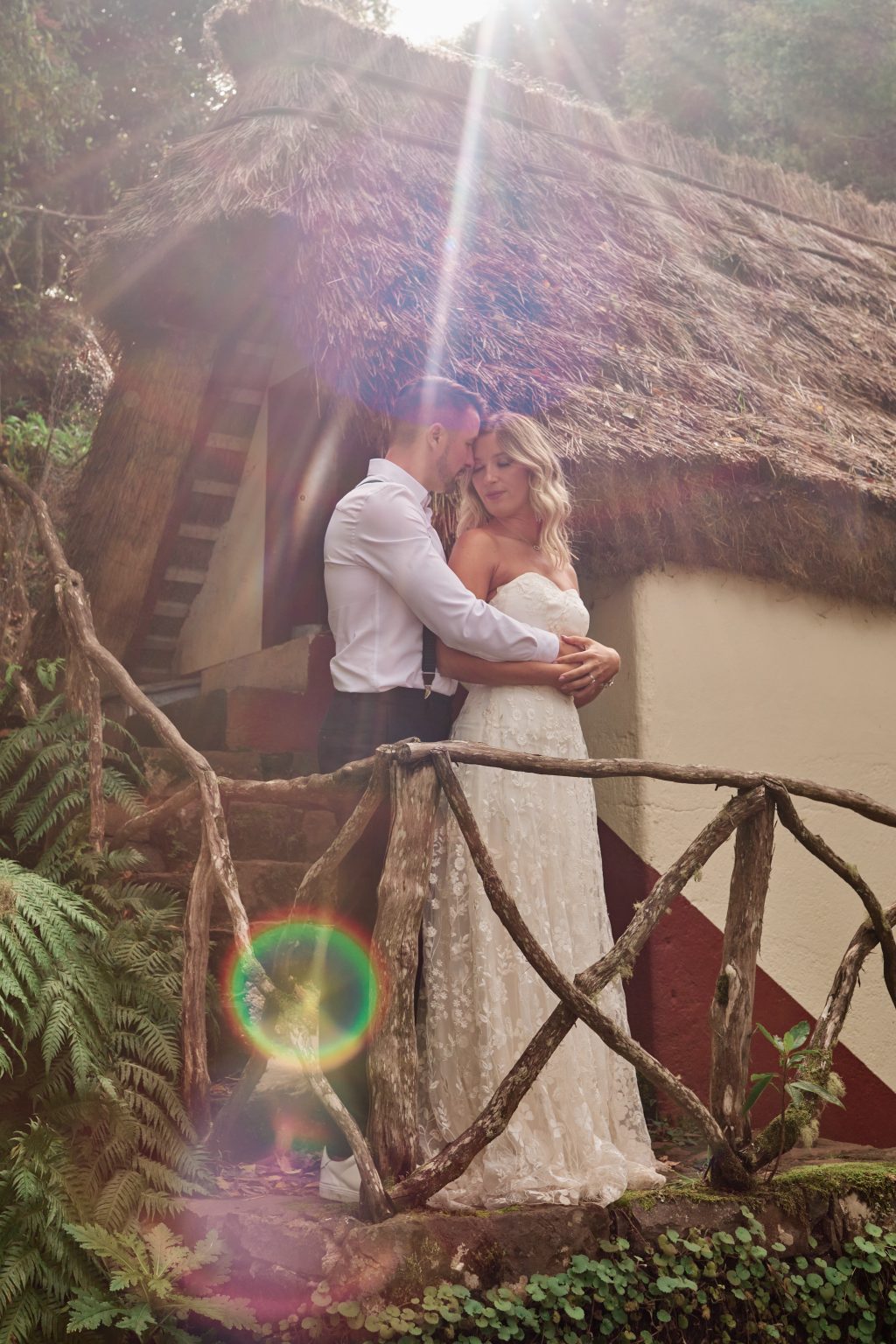 Couple on the balcony of a thatched house at Parque Florestal das Queimadas, Madeira