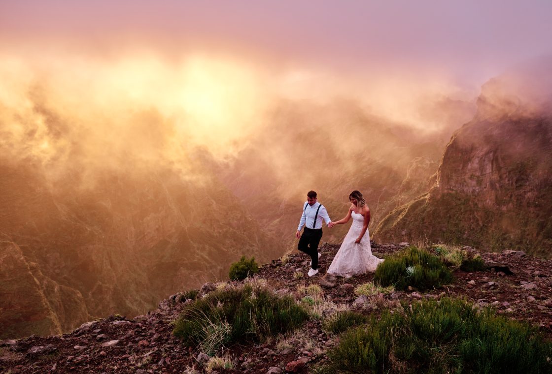 Couple on Pico do Arieiro at an intense pink and orange sunset, Madeira