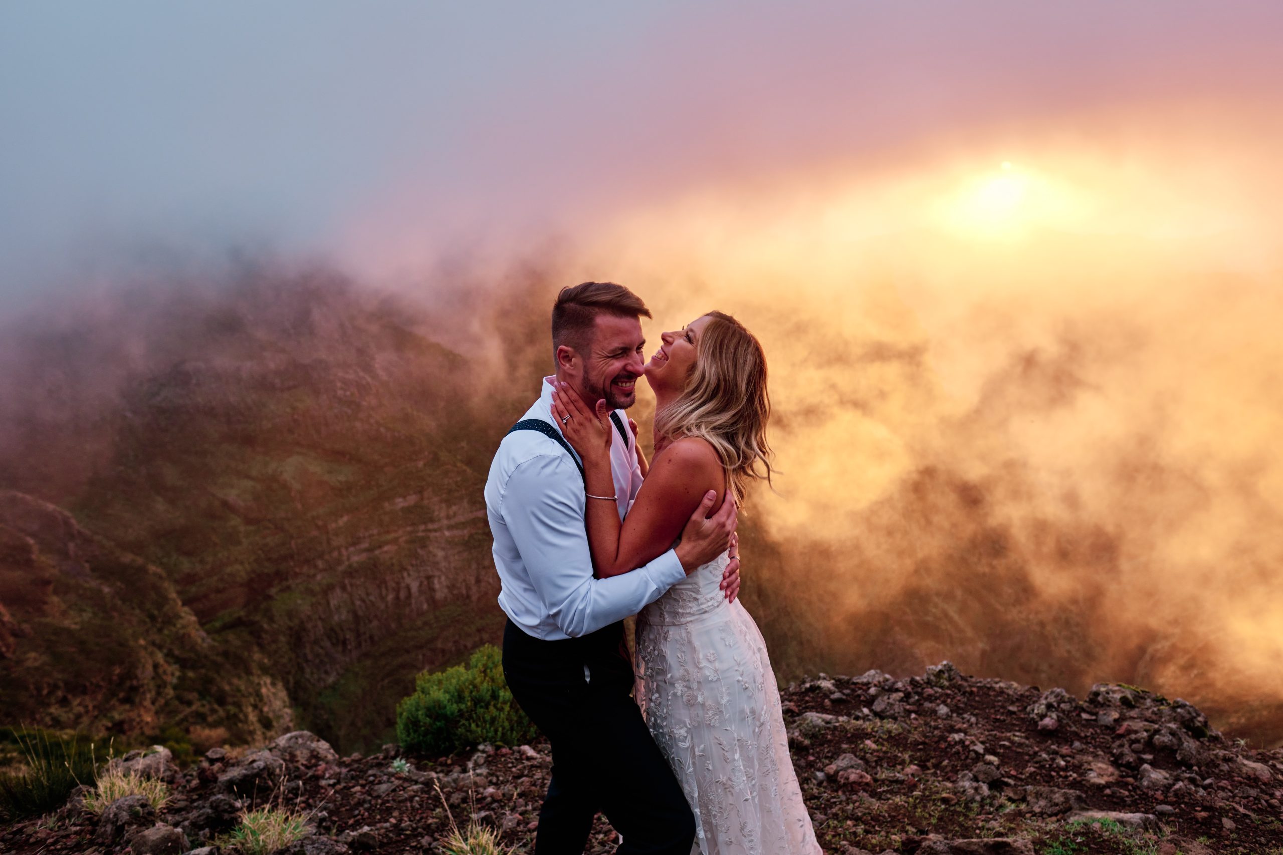 Couple embracing in fiery sunset light on Pico do Arieiro, Madeira
