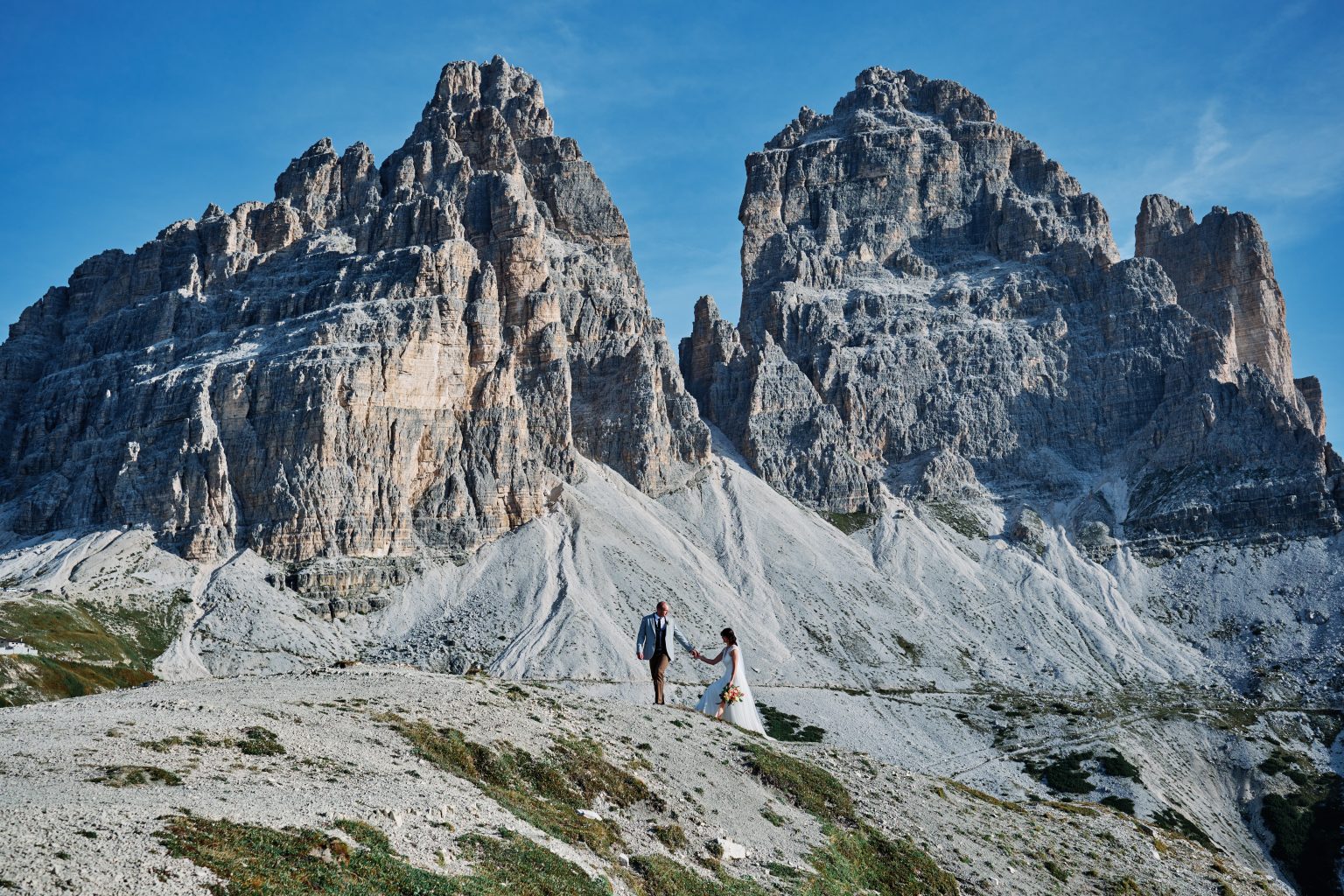Lottie and Jack dwarfed by the peaks of Tre Cime di Lavaredo, Dolomites elopement photographer